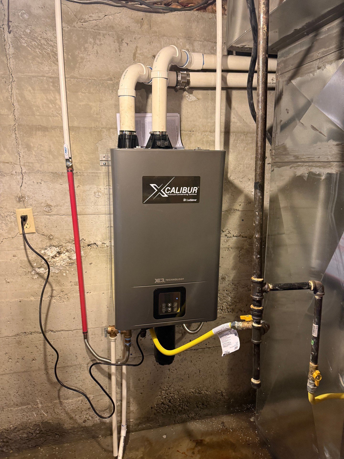 Wrapped up a clean tankless install on this concrete wall&mdash;solid mount with all lines properly supported. PVC intake and exhaust run horizontally through the wall, the cold side has a shut-off, and the yellow flex gas ties into black iron with s