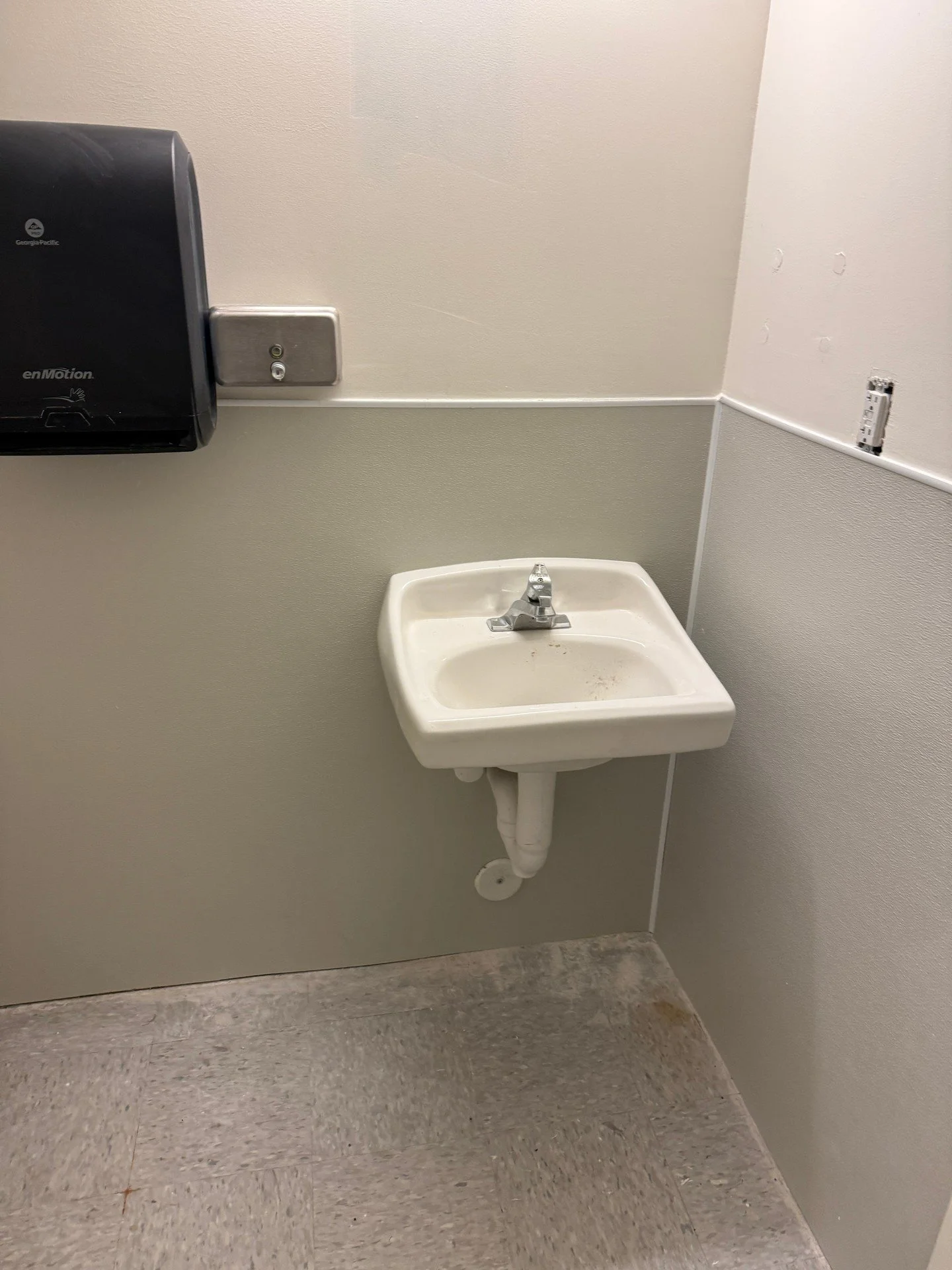 Nothing flashy here&mdash;just a functional wall-mounted sink with a proper P-trap to block sewer gases. Supply lines aren&rsquo;t in view on this setup. Could use a quick wipe-down on the sink and floor, but the plumbing is solid. Another steady day