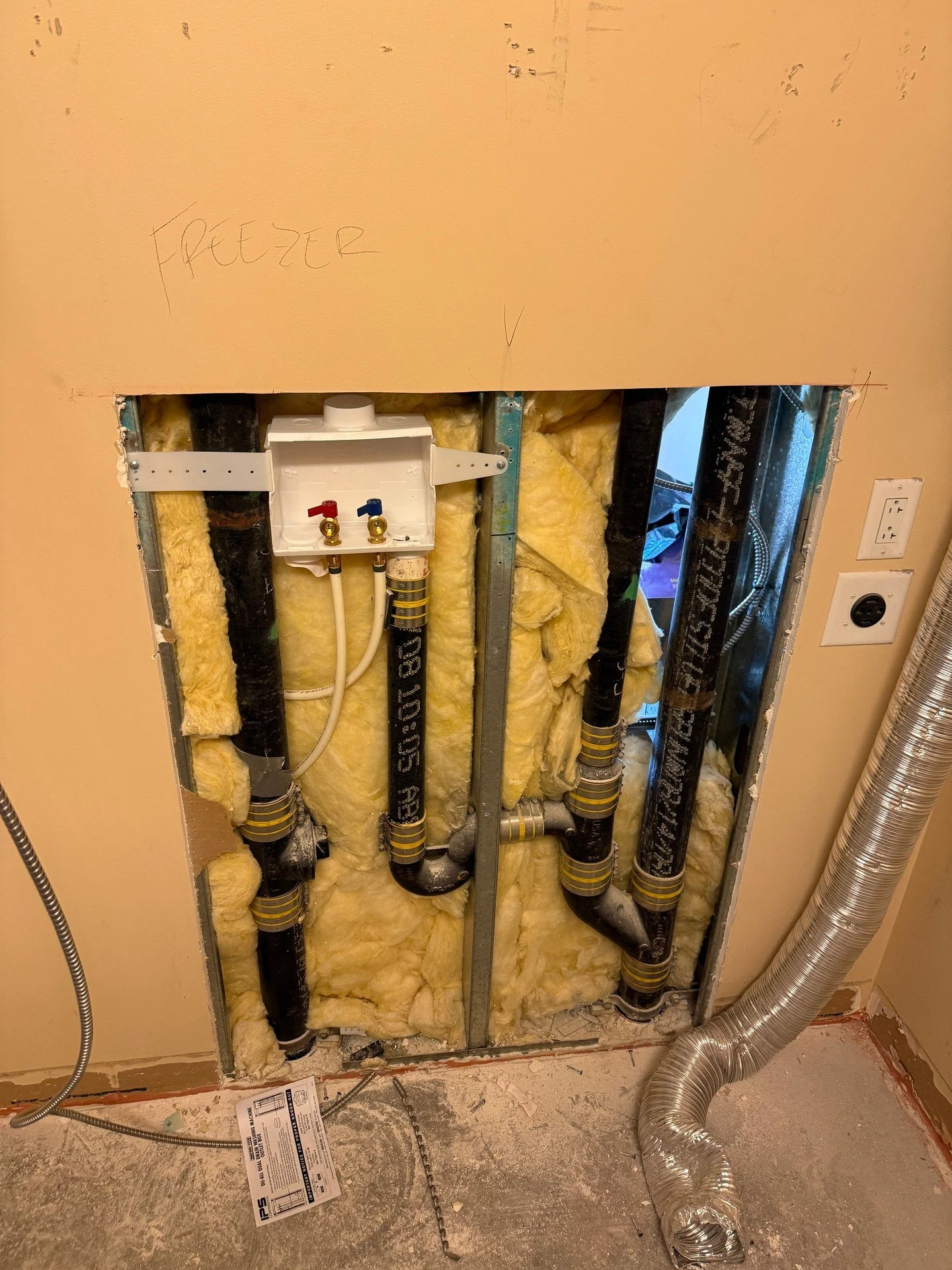 Wrapped up a laundry rough-in today. Washer box set with hot (red) and cold (blue) valves, and the drain tied in with clean couplings and elbows. Fiberglass insulation is back in the cavity, with a run of flex duct nearby. Simple, tidy, and ready for