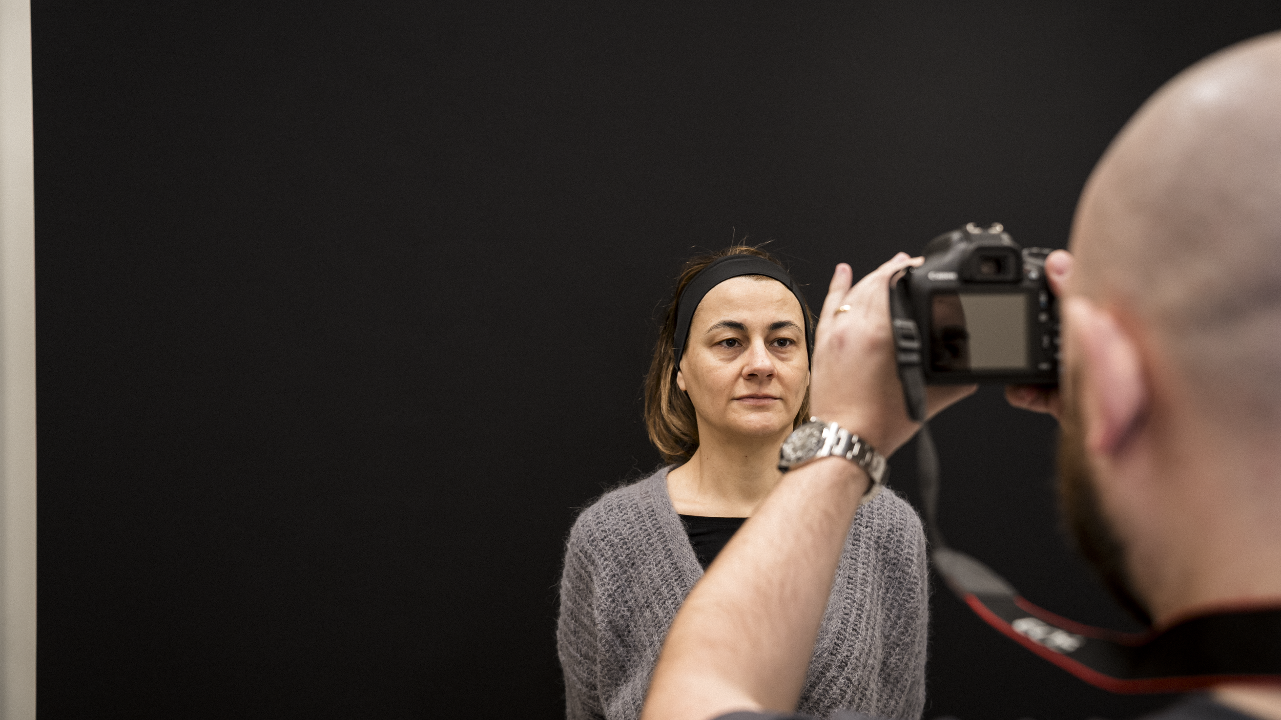 Una donna si sta facendo un ritratto fotografico da un uomo che tiene una macchina fotografica