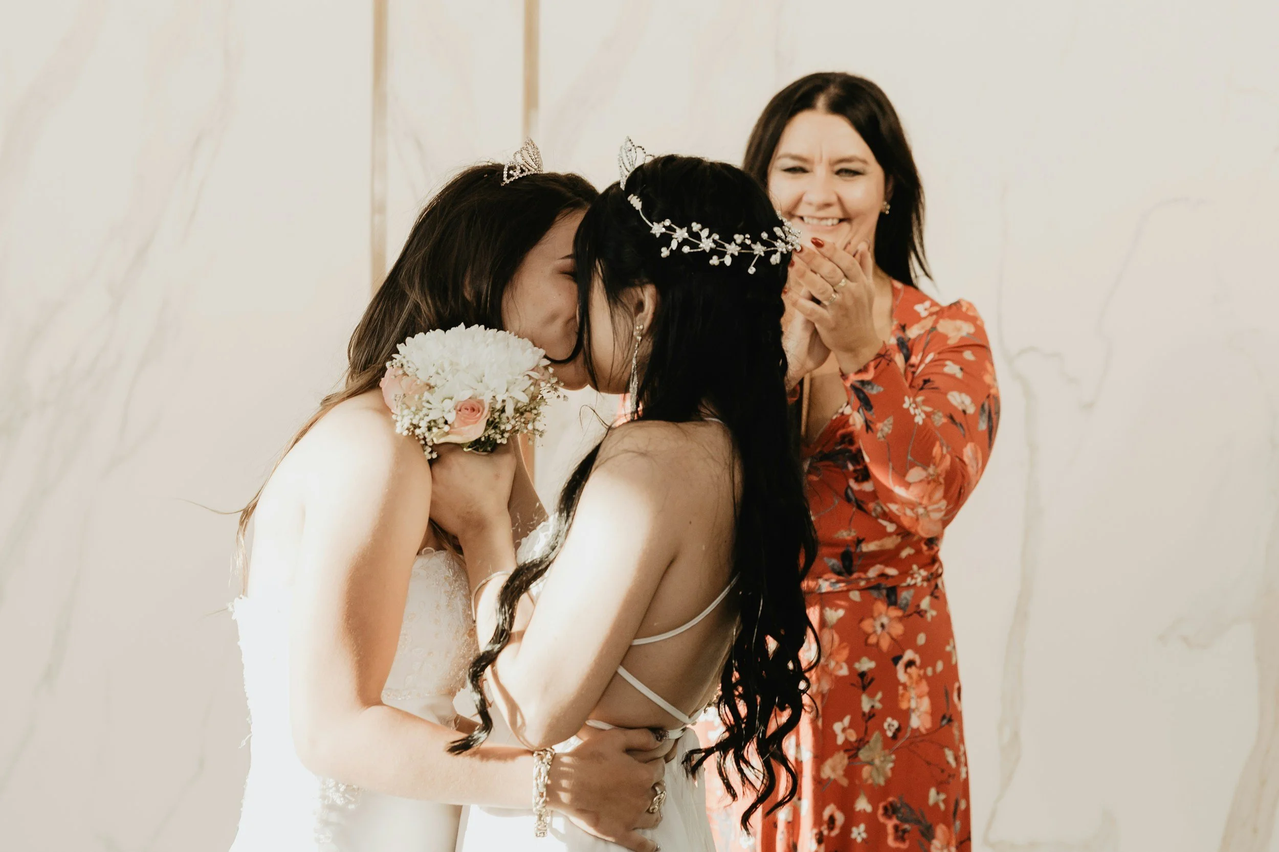 Two women celebrating their wedding day,  sharing a happy moment.