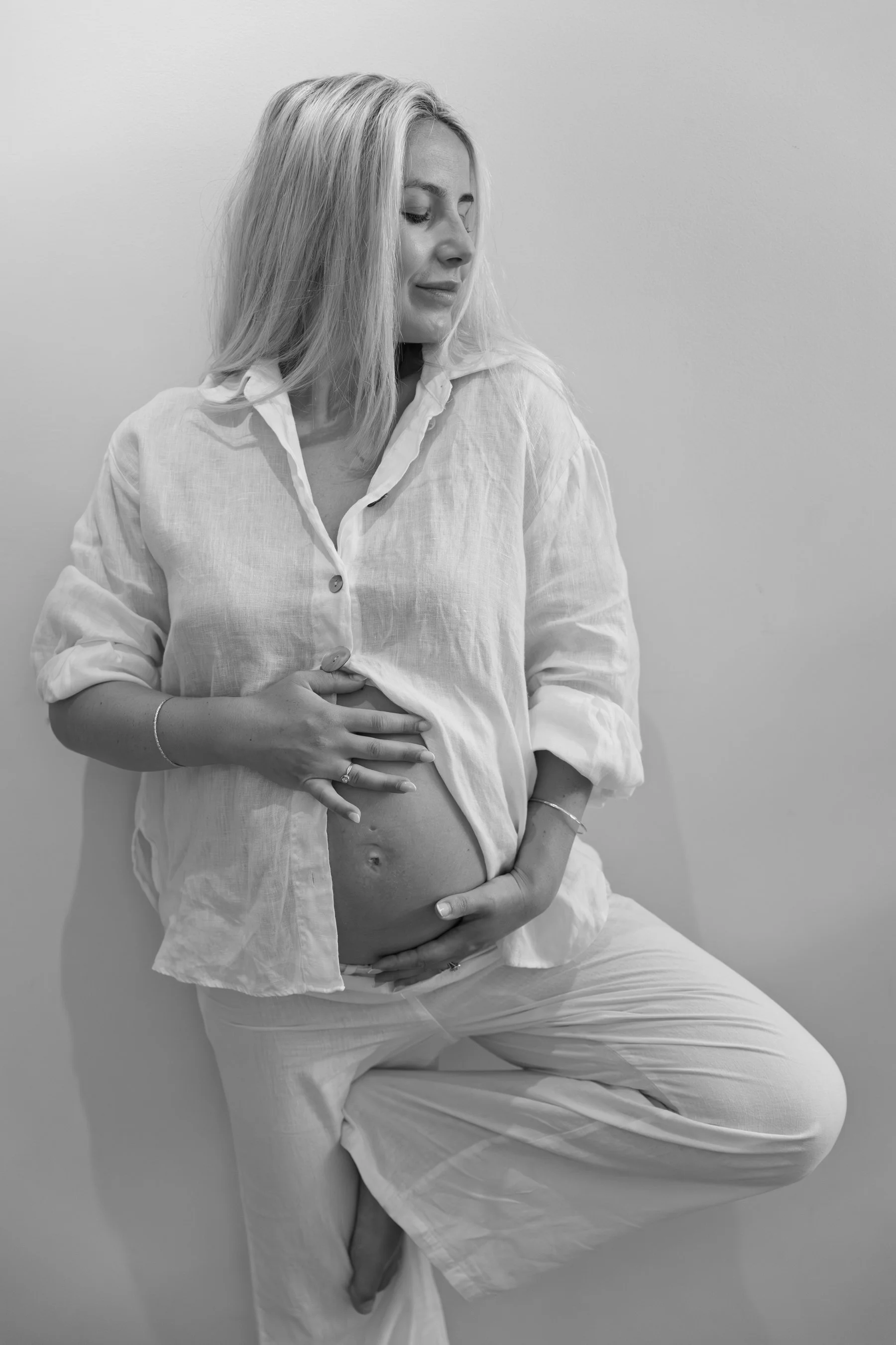 An expectant mum performing a serene yoga pose during a lifestyle pregnancy photography session with a South West London photographer.
