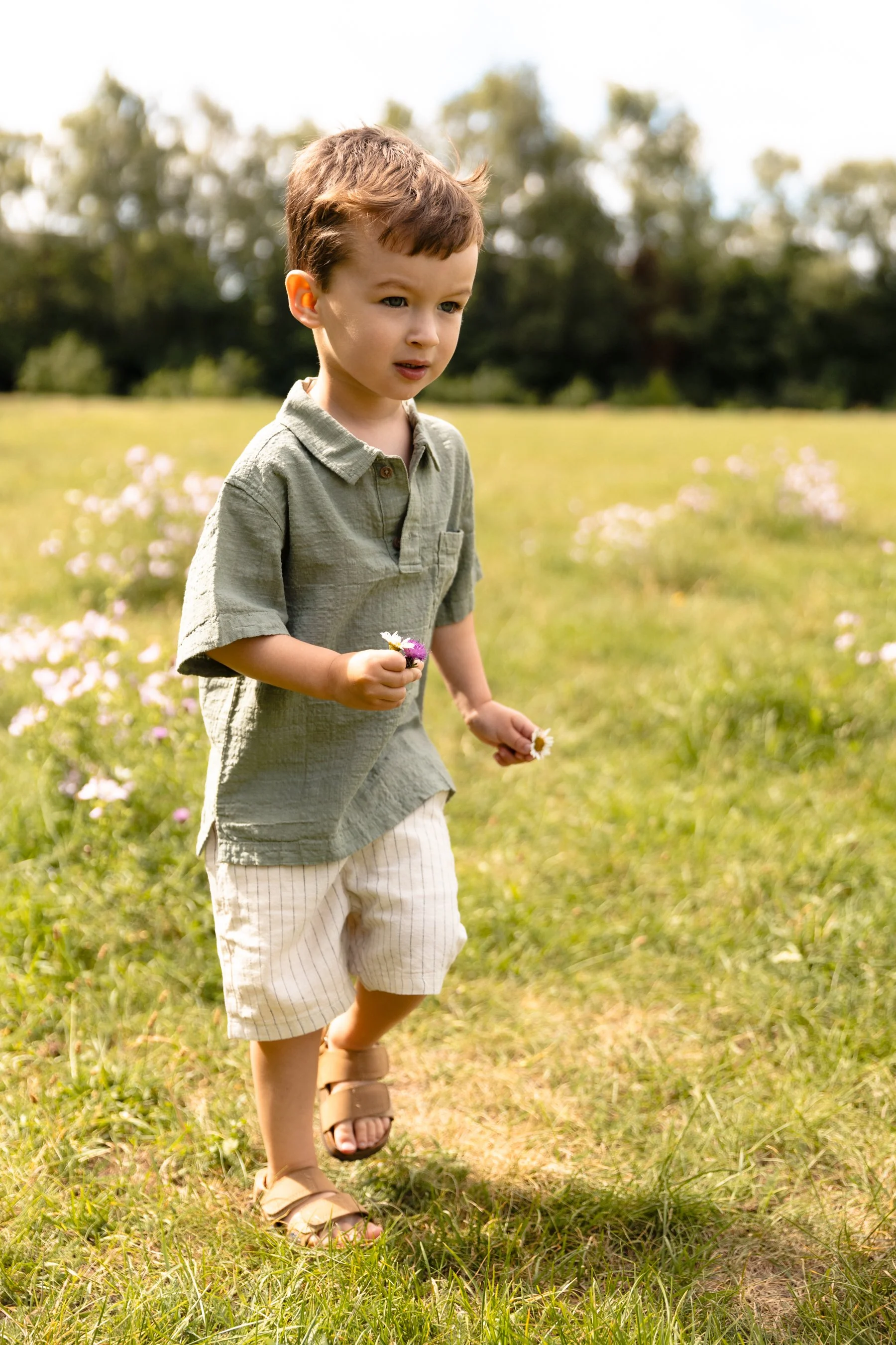 a young boy holds a flower whilst at pregnancy photoshoot before the arrival of his new baby sister in Earlsfield