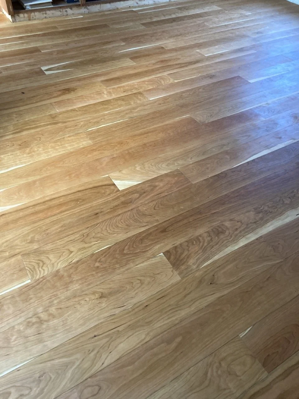 Close-up of a hardwood wooden floor with natural wood grain and finish.