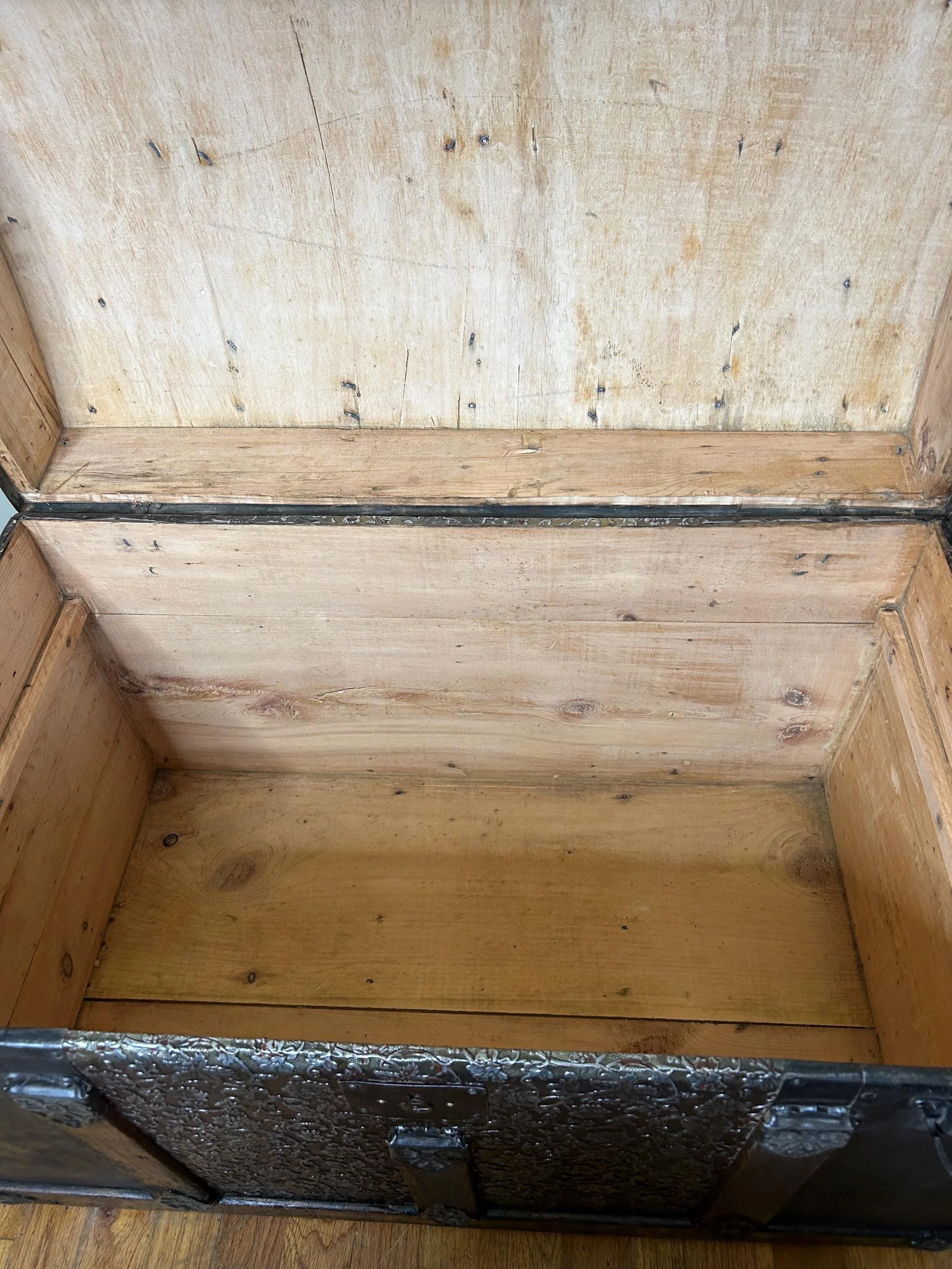 Inside view of a clean, pristine antique trunk interior, stripped and sanded for storage.