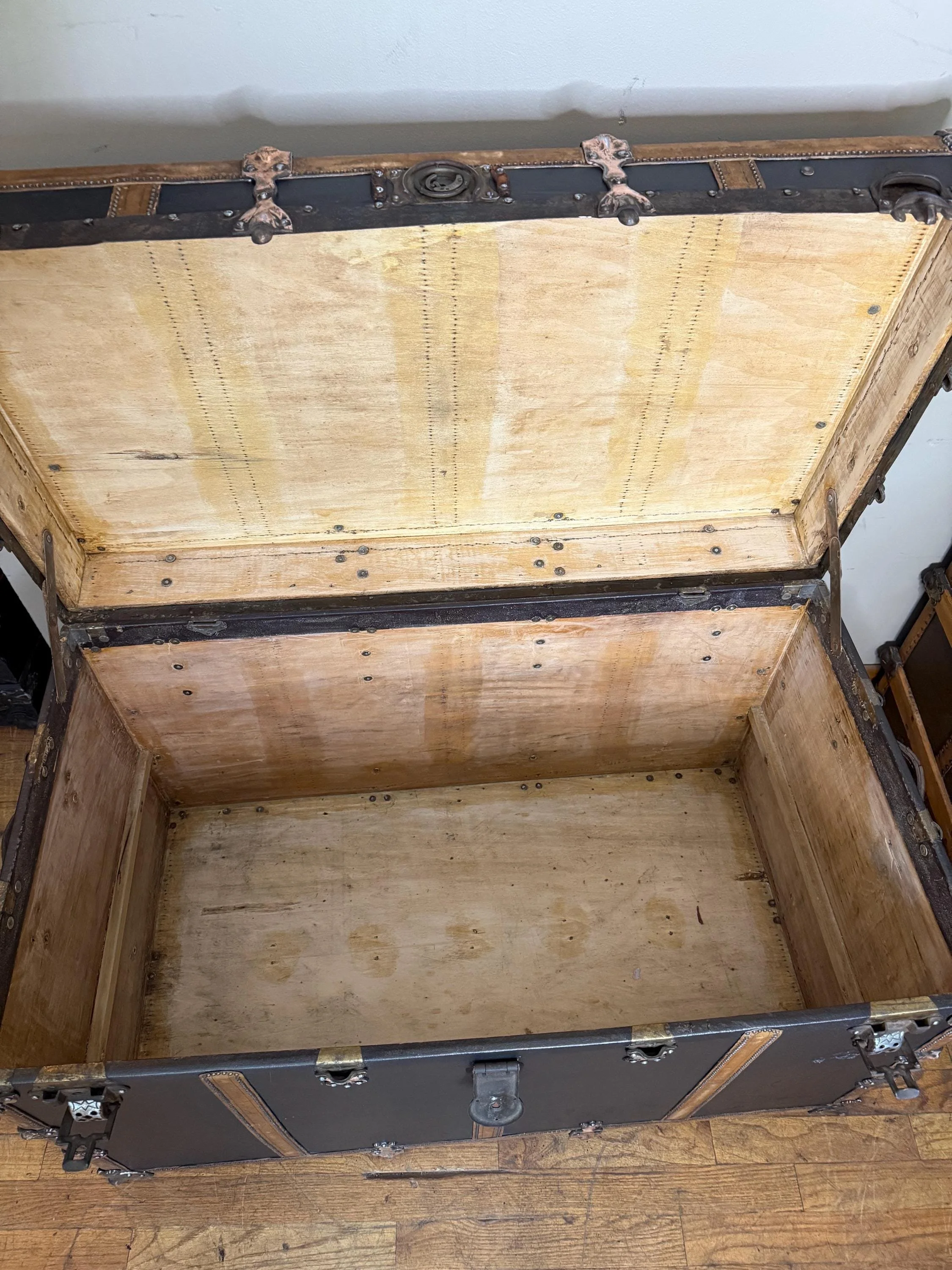 Interior view showing the deep, spacious storage area of an extra-large antique trunk.