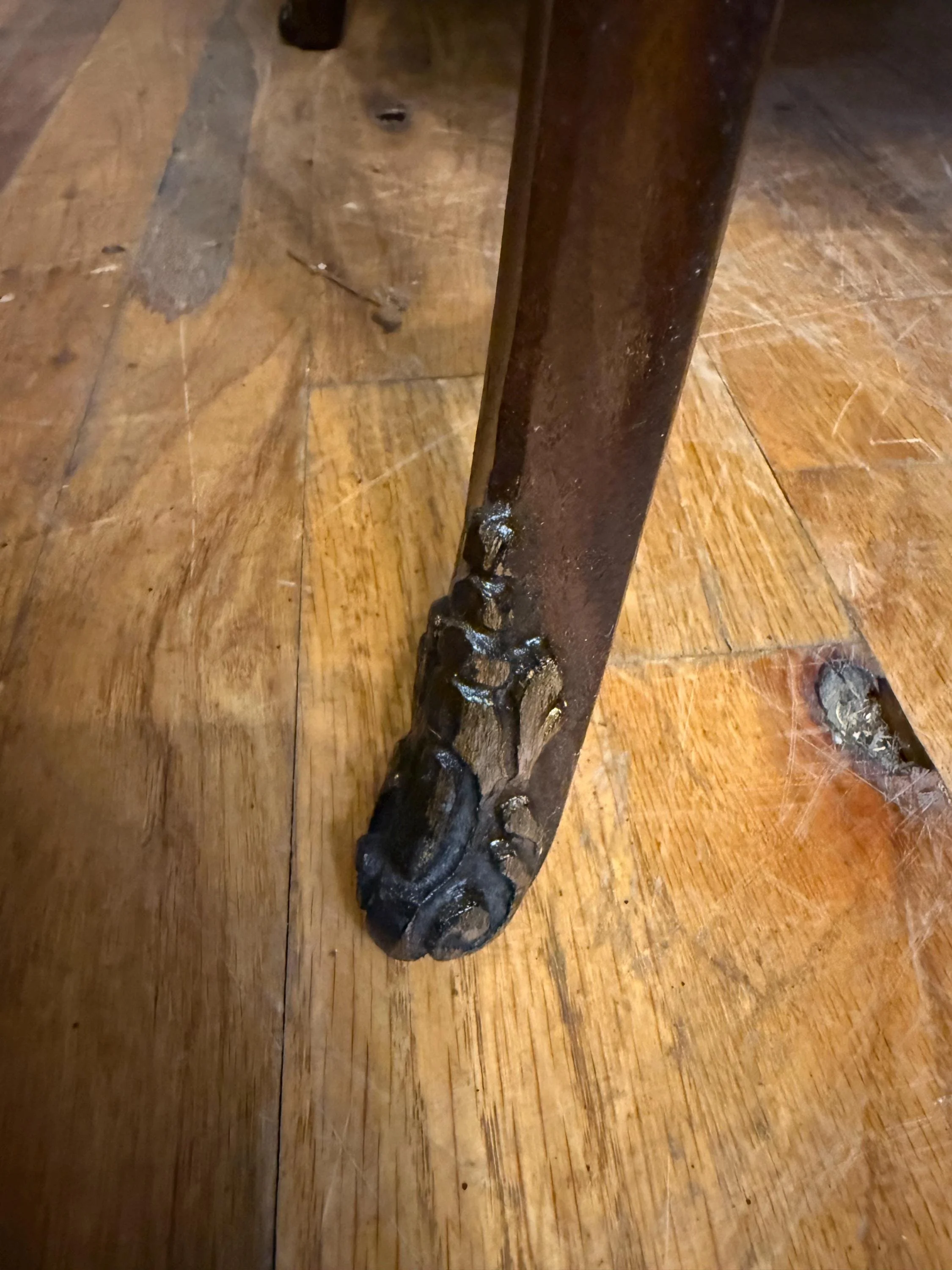 Detailed view of the hand-carved legs and structural integrity of an antique lamp table.