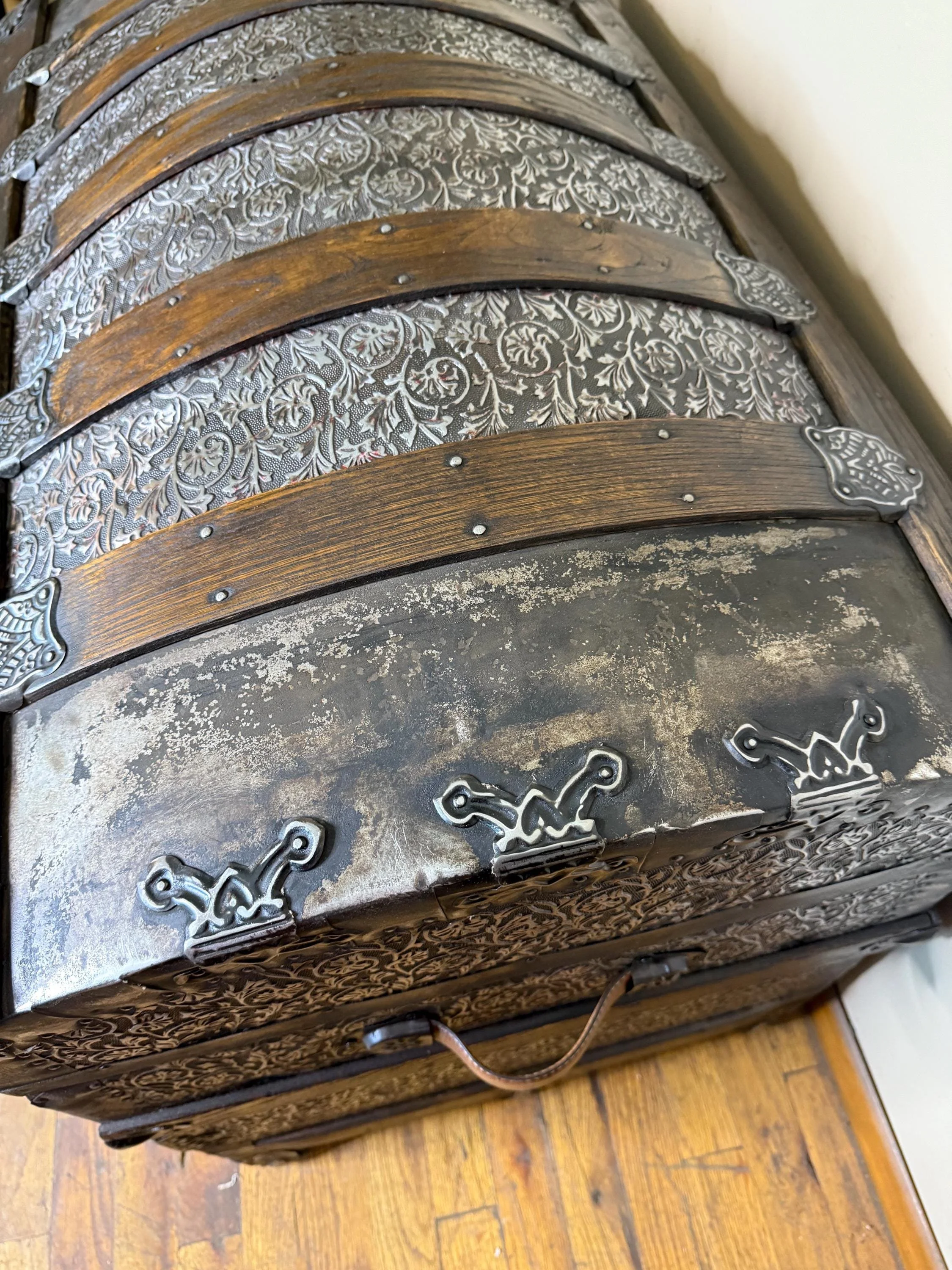 Detailed close-up of rare floral relief metal pattern with copper and red accents.