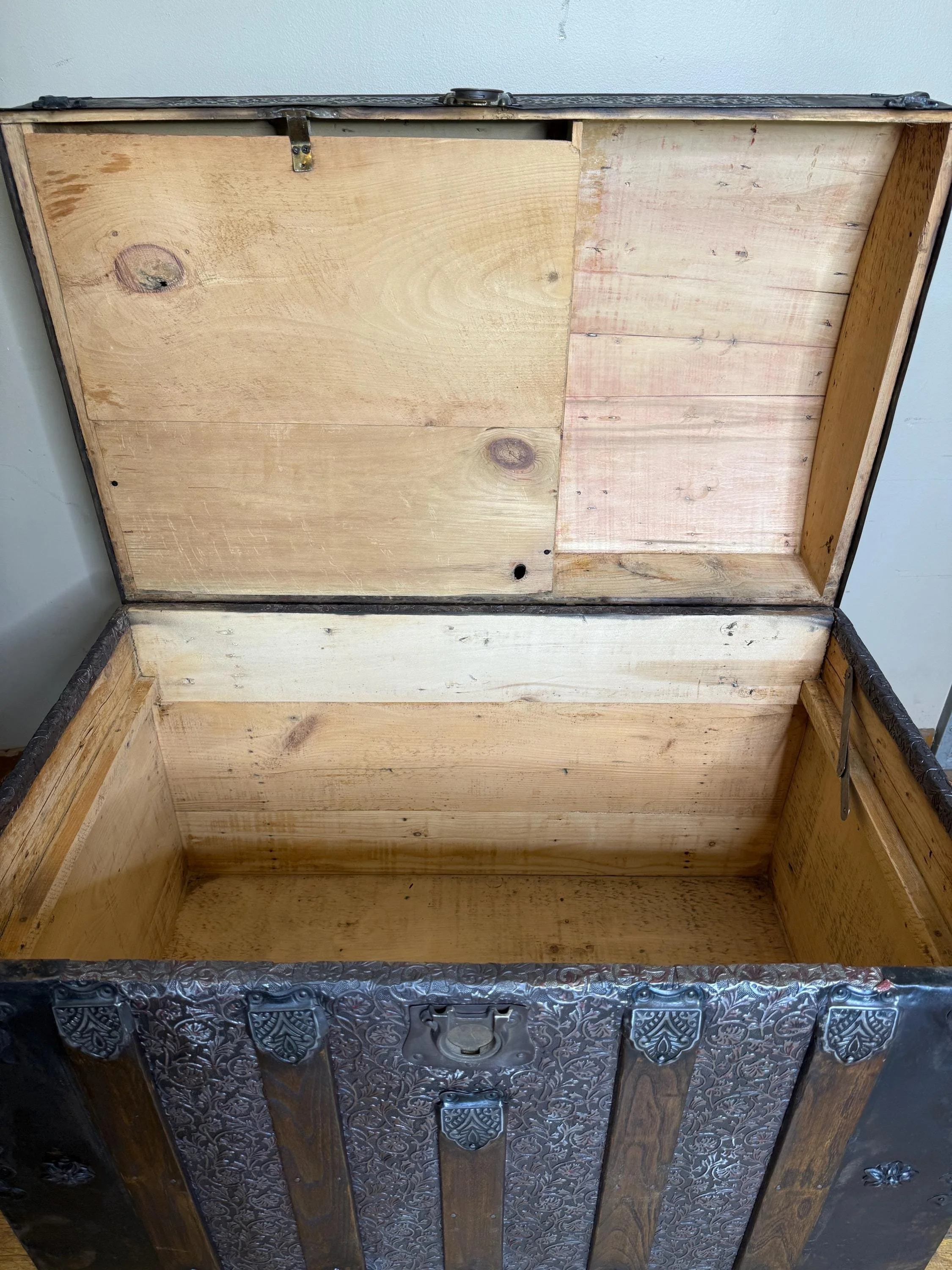 Inside view of a clean, pristine antique trunk interior, stripped and sanded for modern storage.