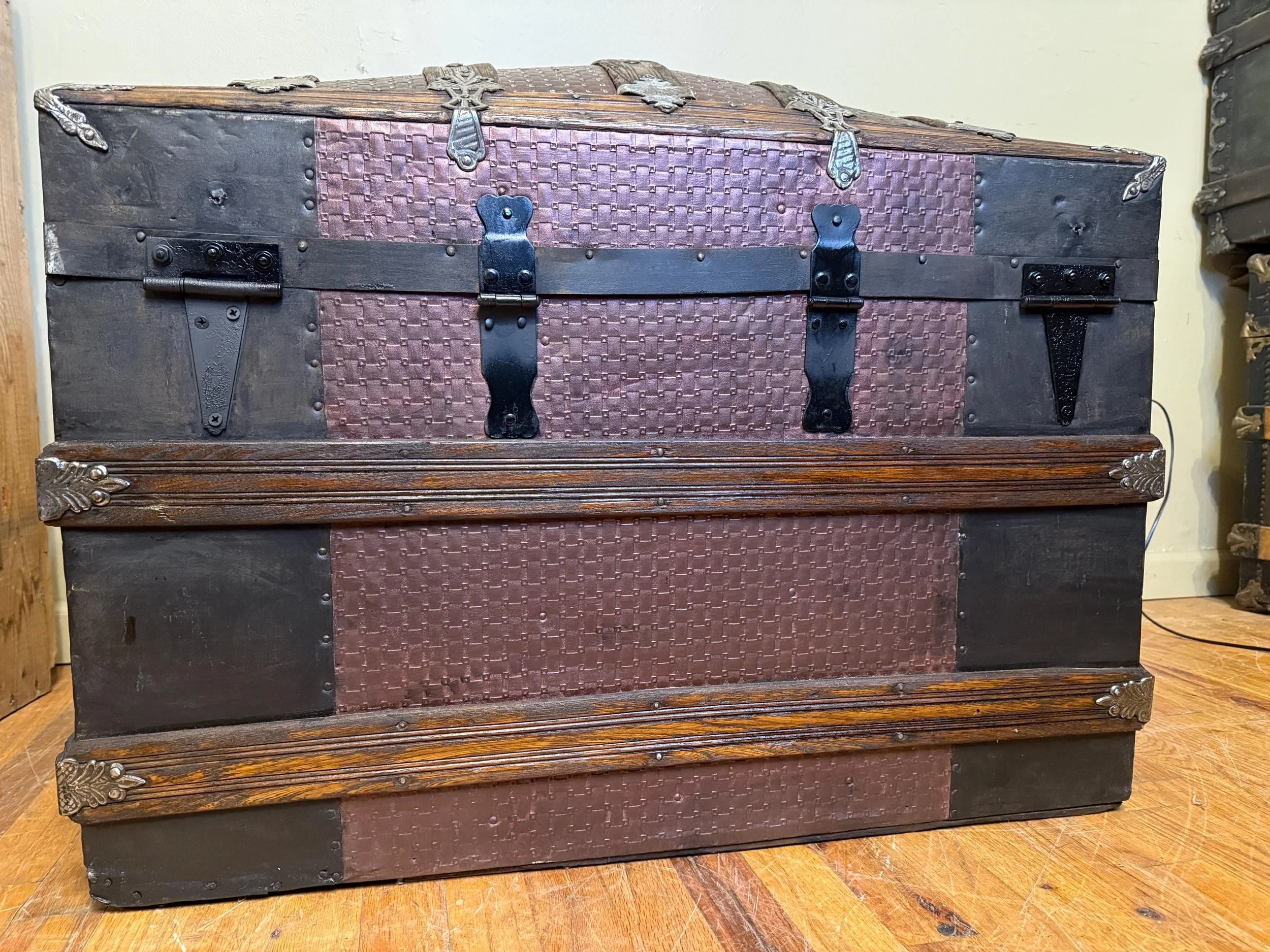 Heavy-duty original metal hinges and refinished structural banding on a Saratoga chest.