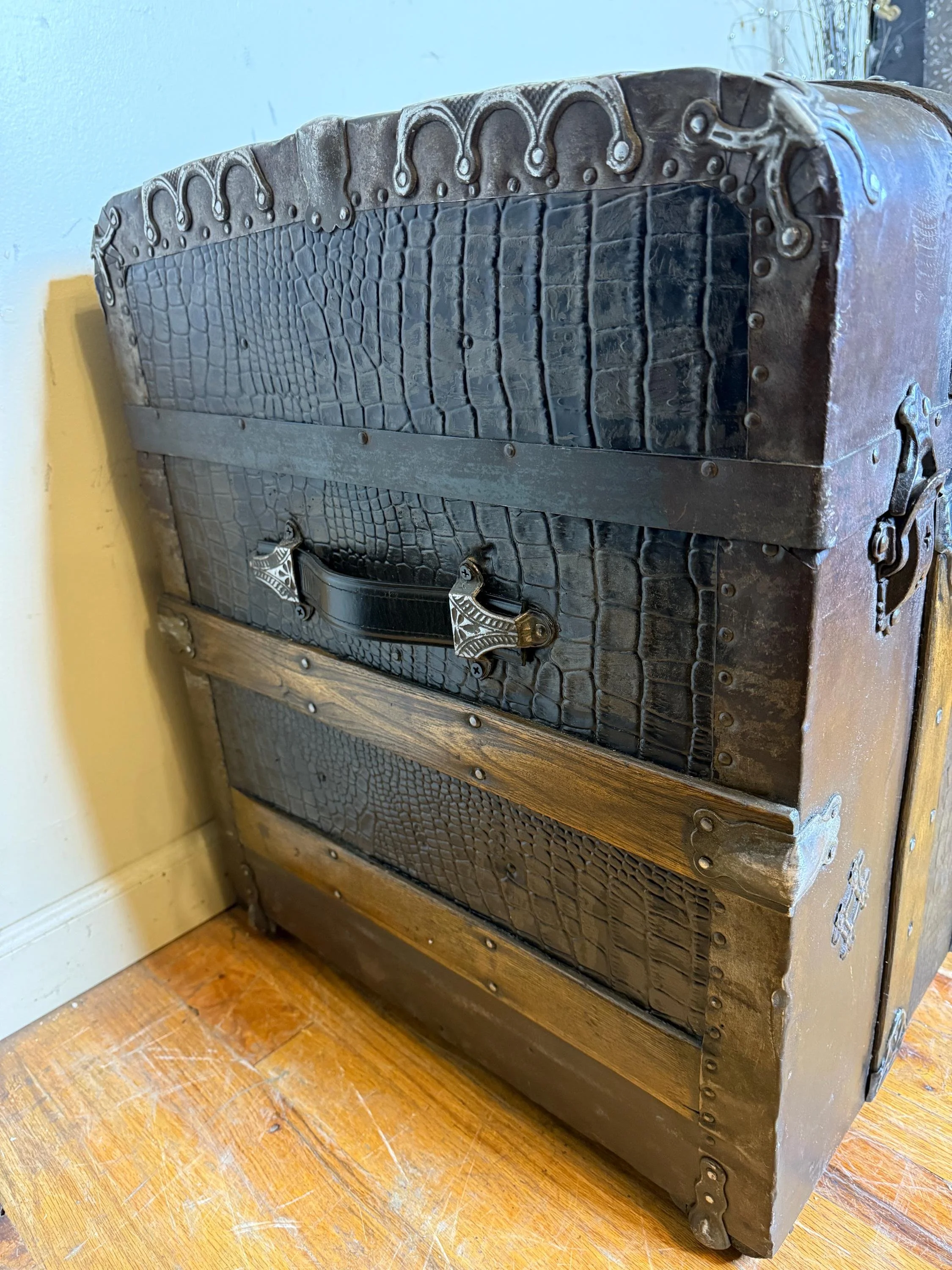 New custom black leather handles on a professionally refinished travel trunk.