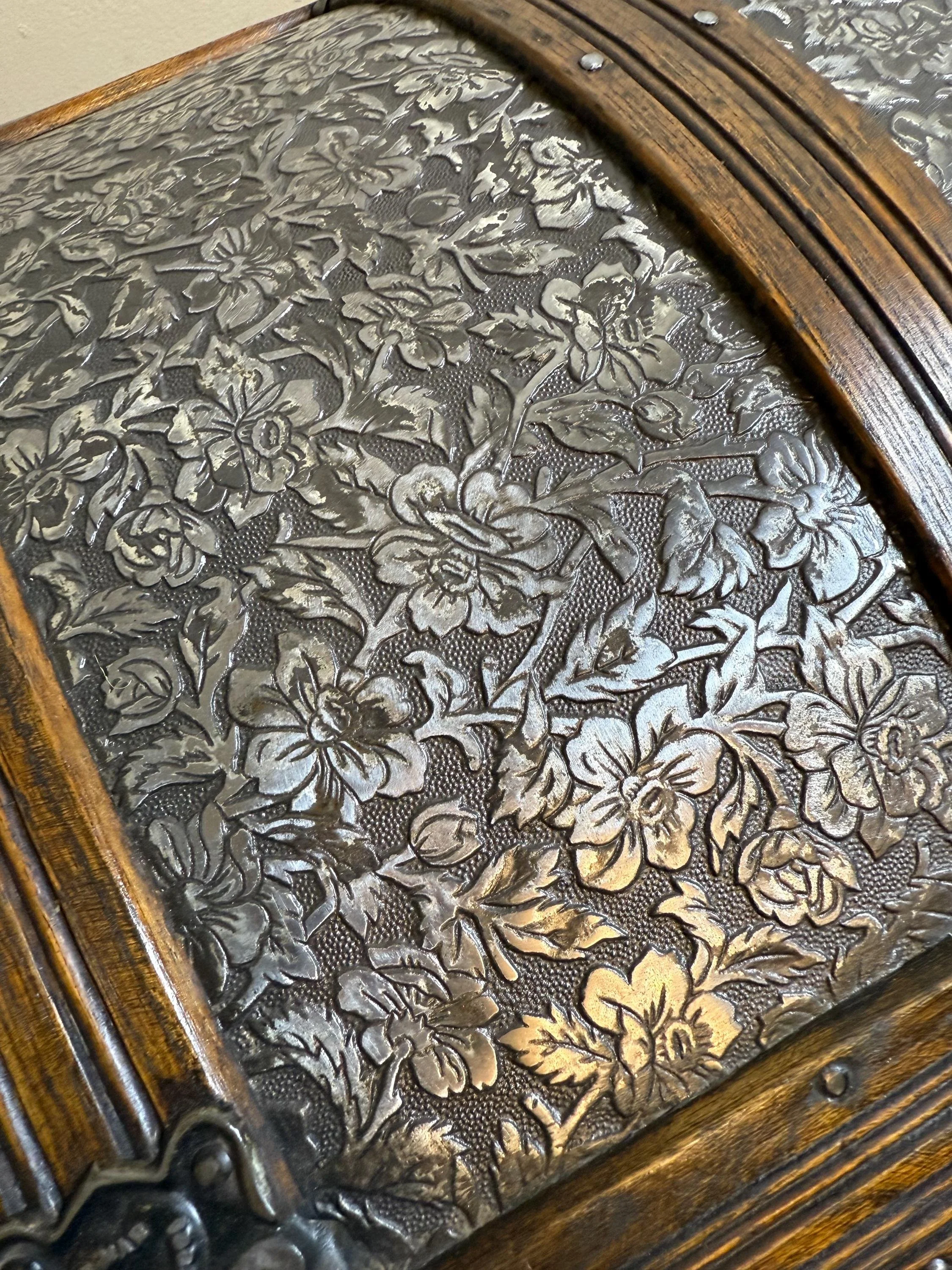 Detailed close-up of the rare metallic relief floral pattern on an 1800s steamer trunk.