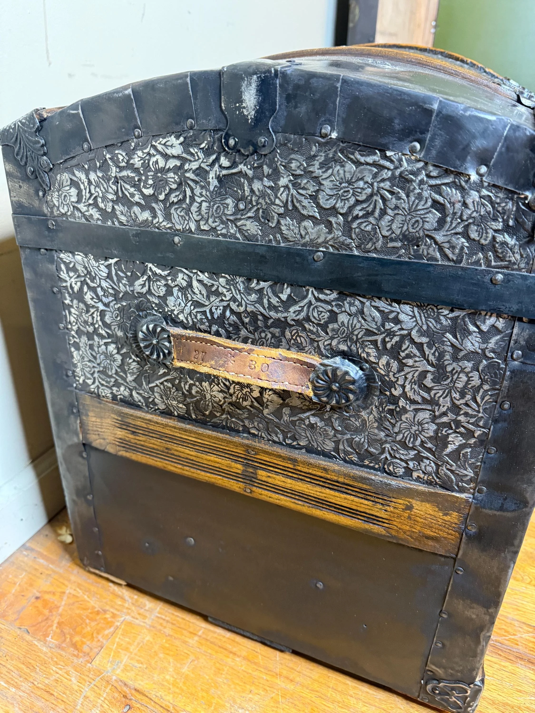 Side profile highlighting the high arched dome lid of a 19th-century travel trunk.