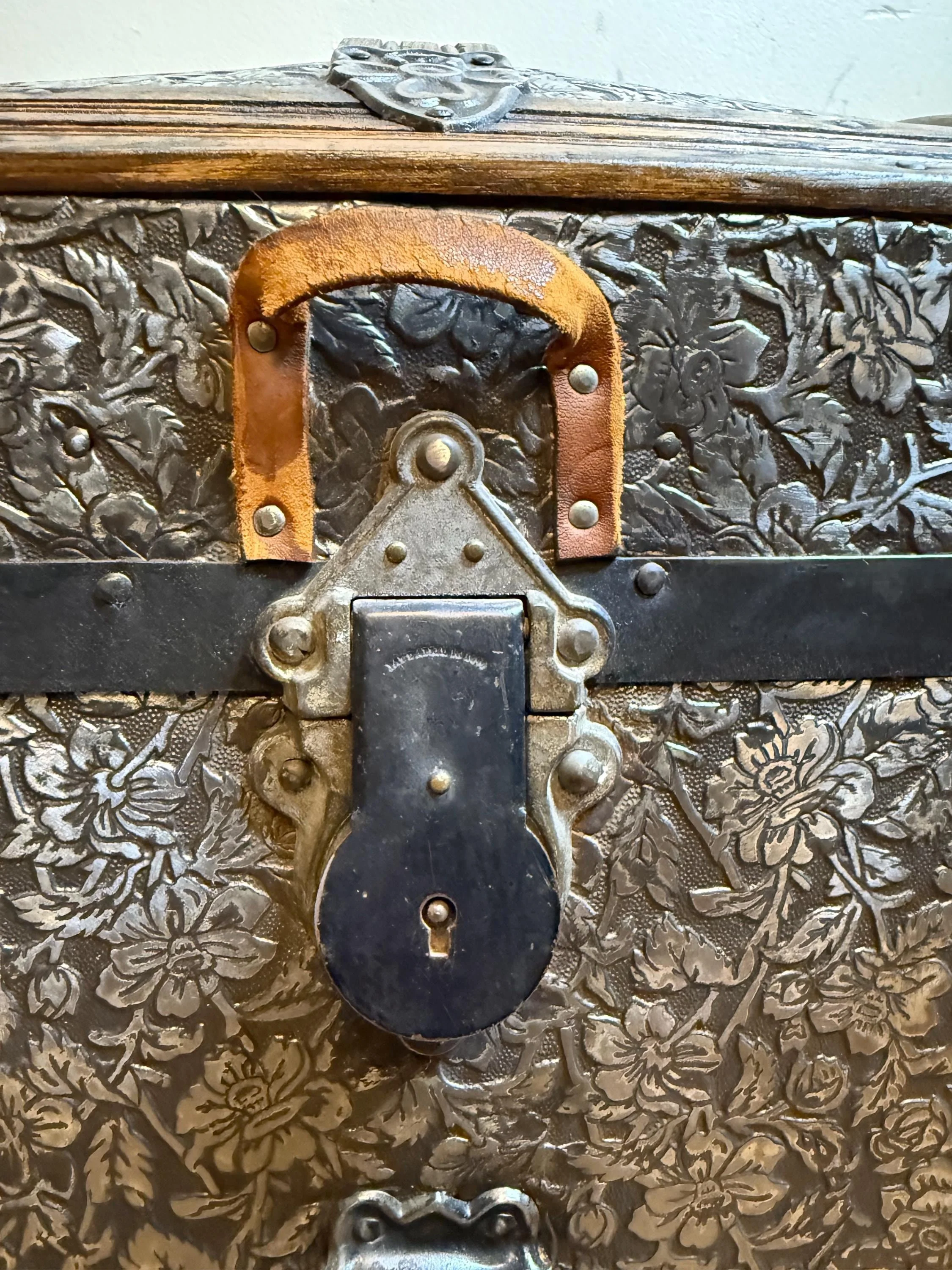 Detailed view of the original ornate center lock hasp, buffed to a brilliant shine to highlight the 19th-century craftsmanship.