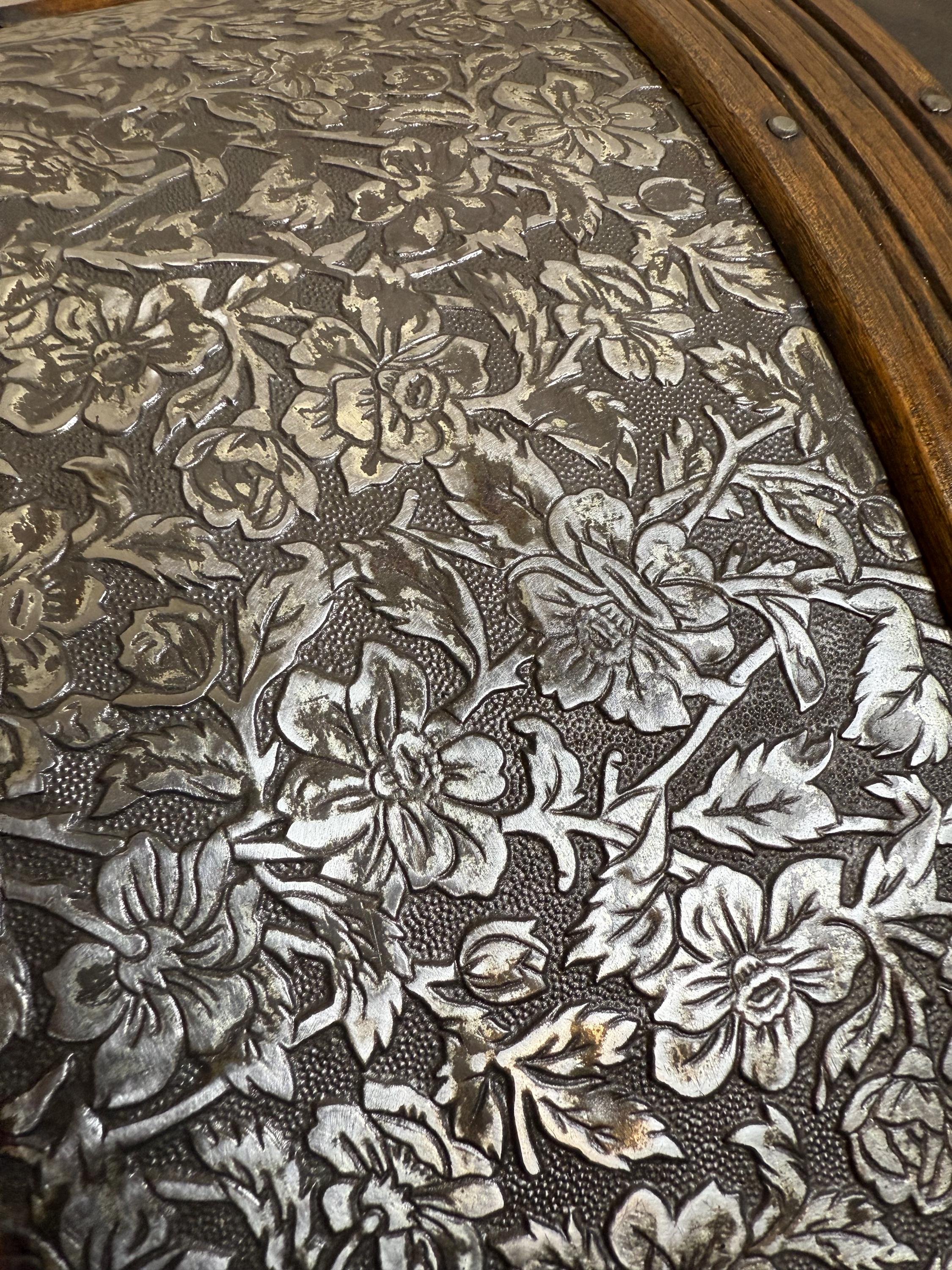 Detailed view of buffed bright floral tin blossoms on a vintage heritage trunk.