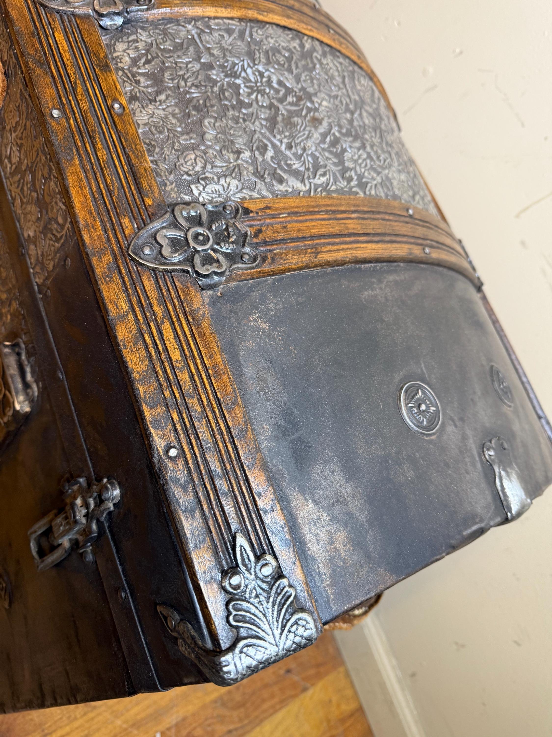 Antique floral embossed treasure chest styled as an elegant entryway statement piece for a heritage-inspired luxury home.