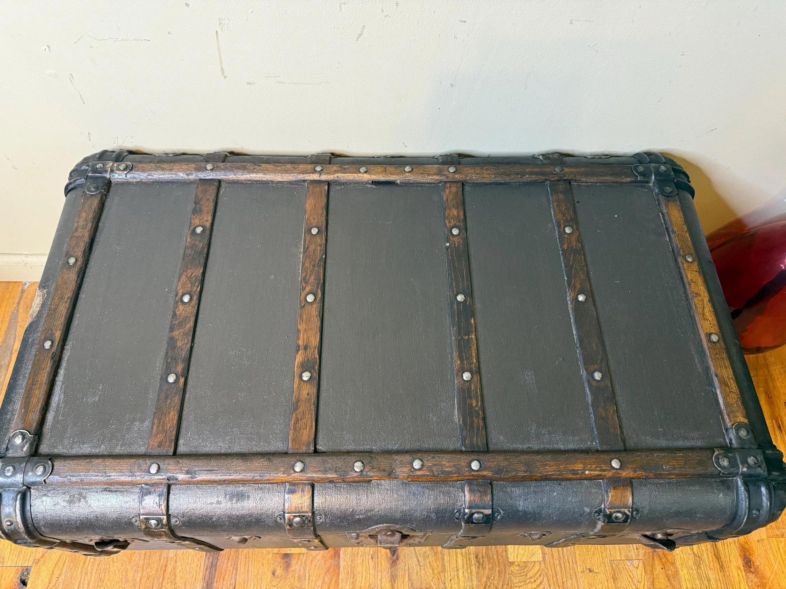 Low profile Indestructo steamer trunk providing a level surface for living room decor.