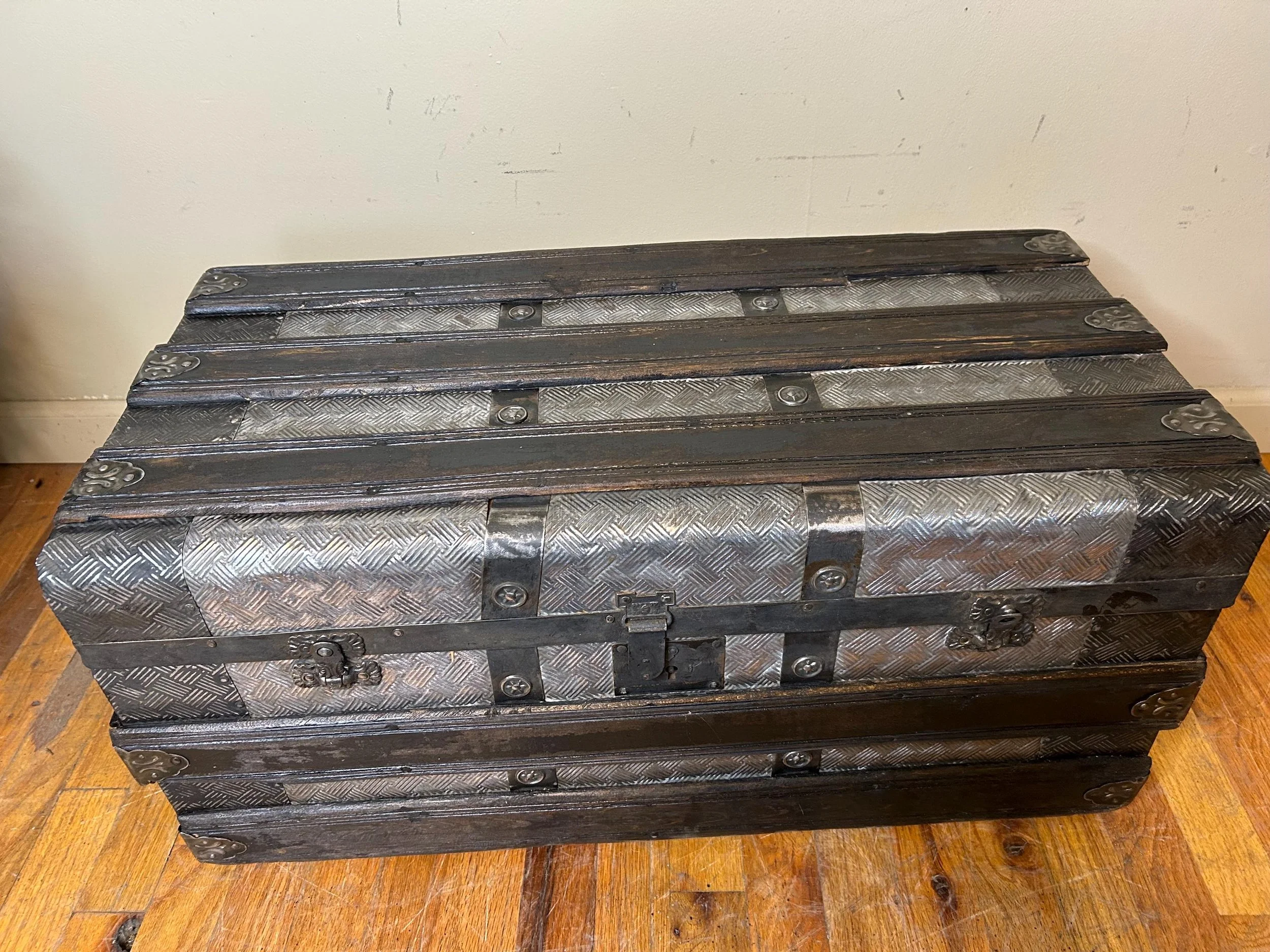 Detailed embossed crosshatched tin pattern on antique trunk