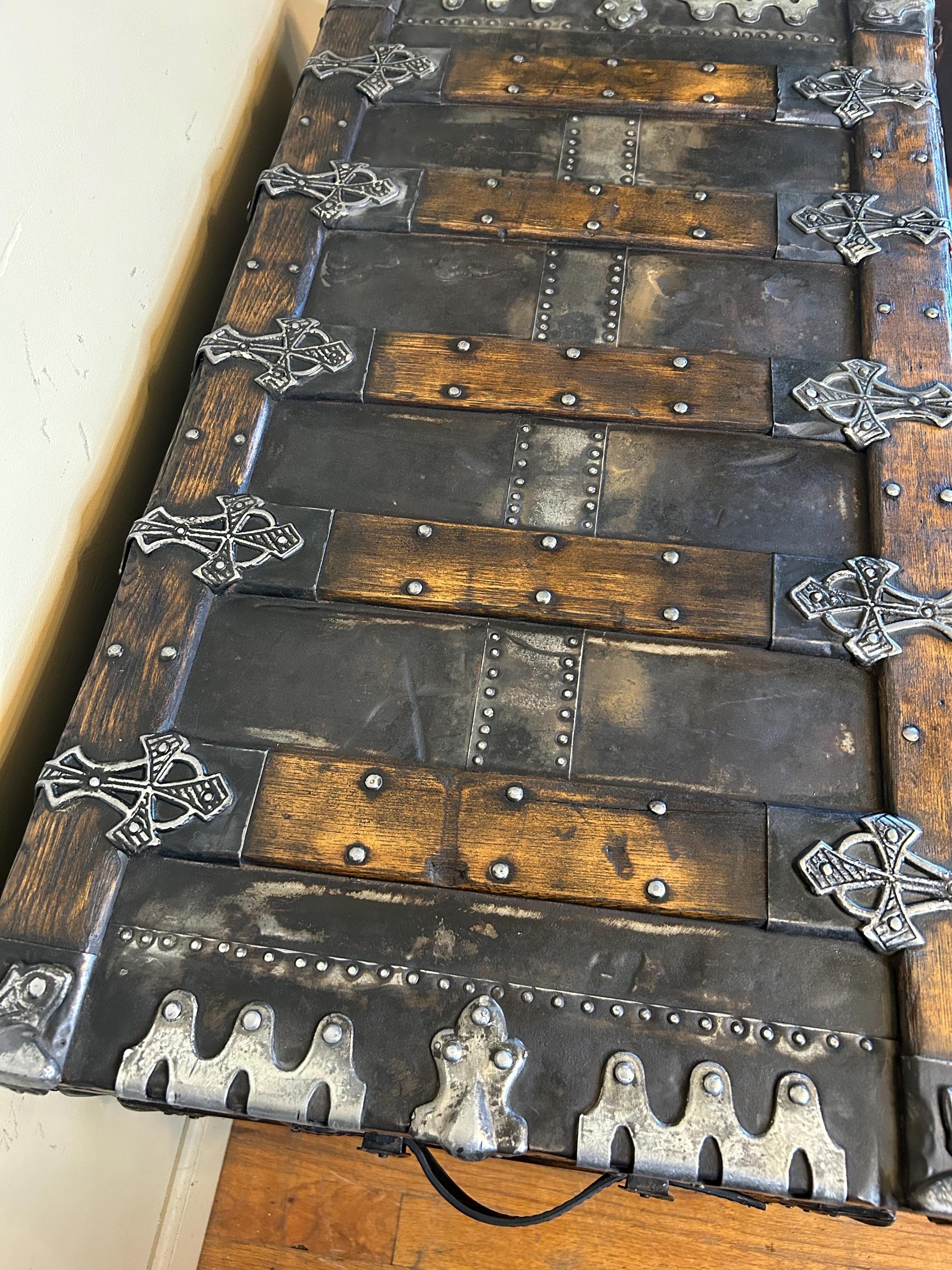 Detailed view of hand-buffed rivets and hardware on a refinished antique trunk.