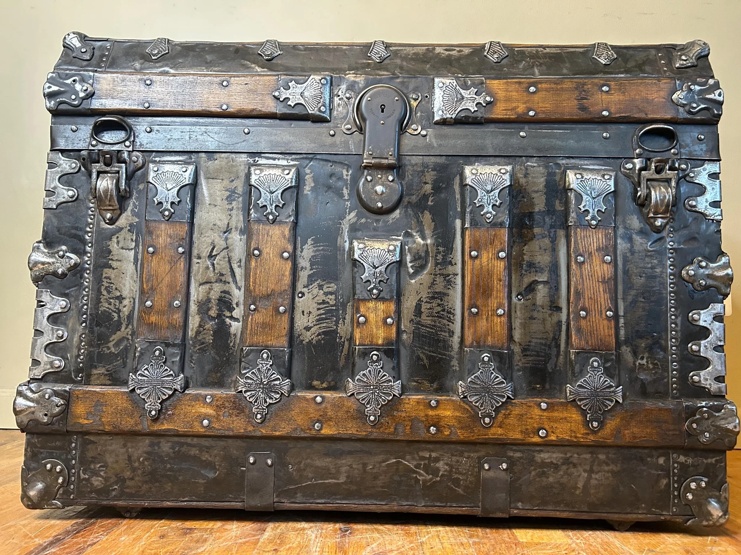 Ornate metal corner protectors and latches on a high-end Victorian steamer chest.