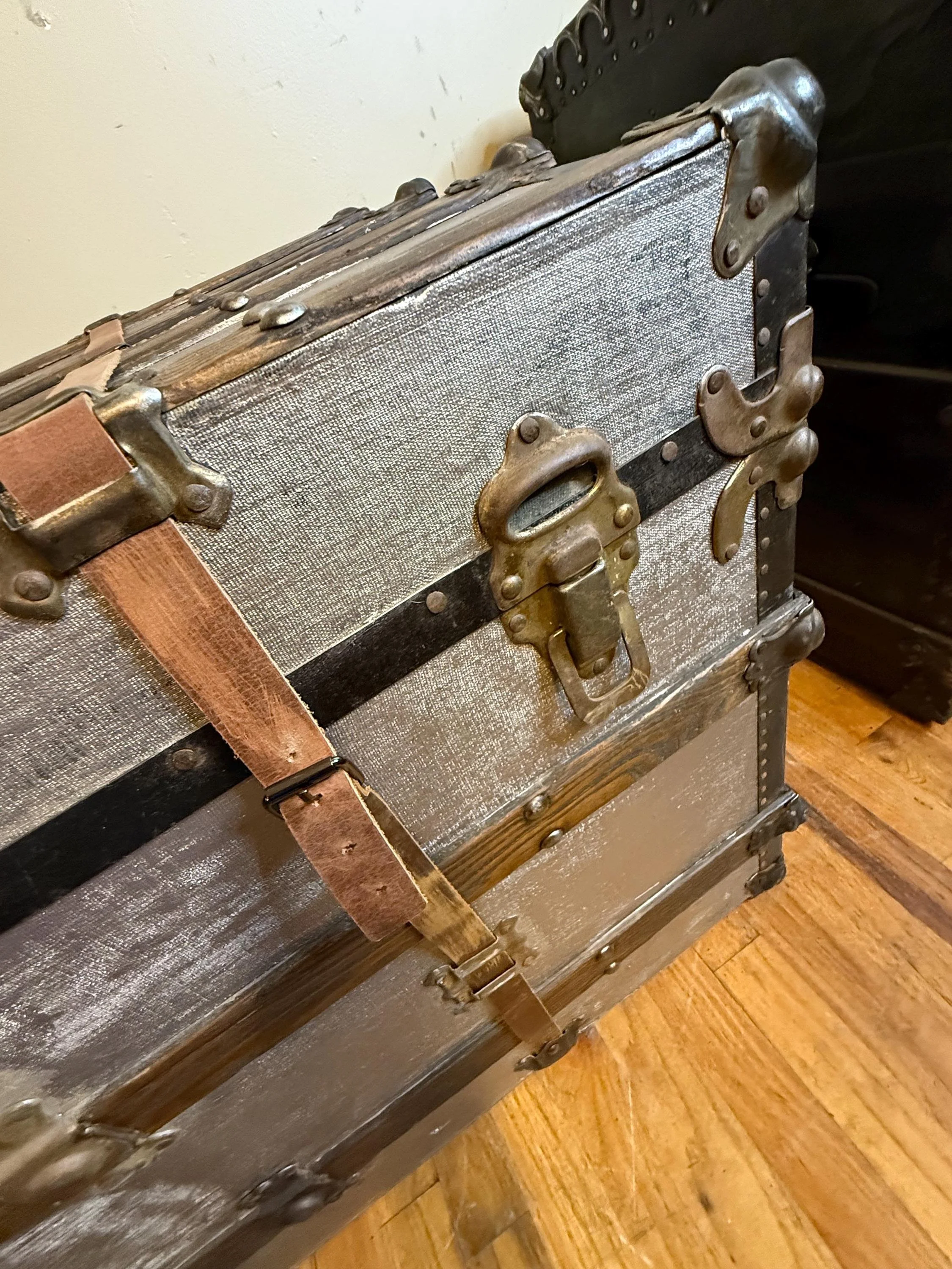 Detailed view of the authentic original metal lock hasp on a silver industrial-style trunk