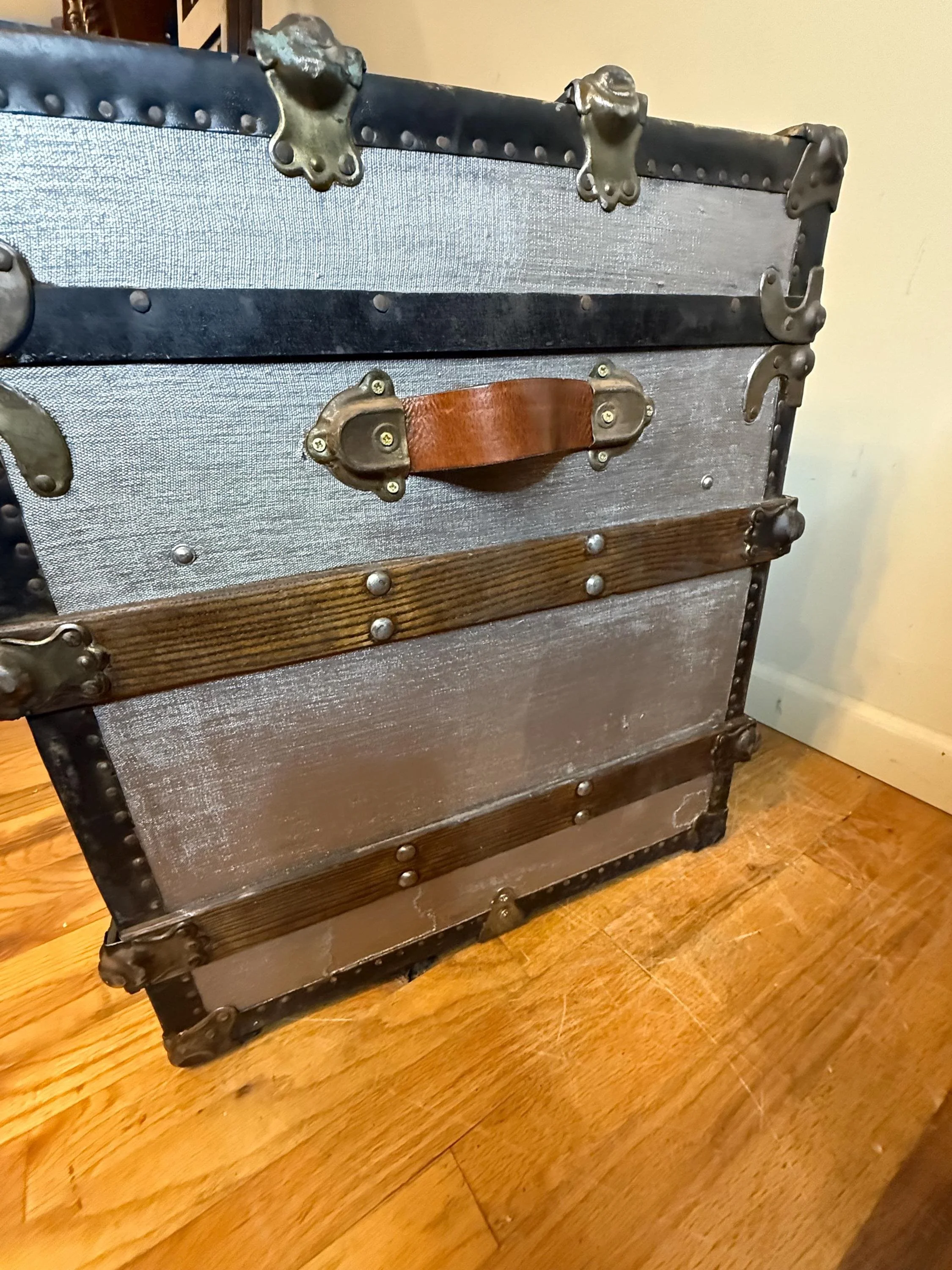 Side view showing the durable vintage leather handles on a refinished 19th-century travel chest.