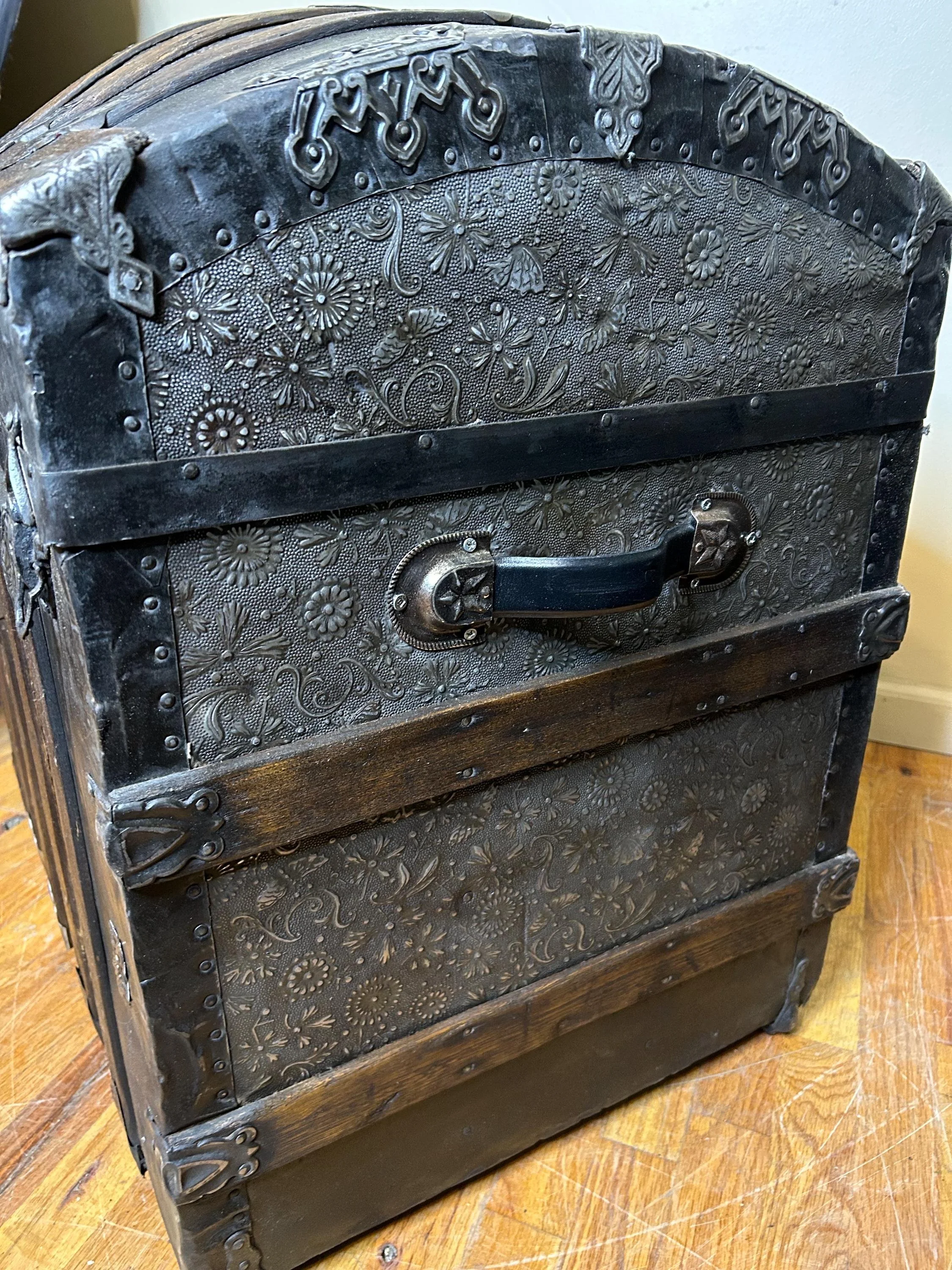 Side profile highlighting the high arched dome lid of a rare floral travel trunk.