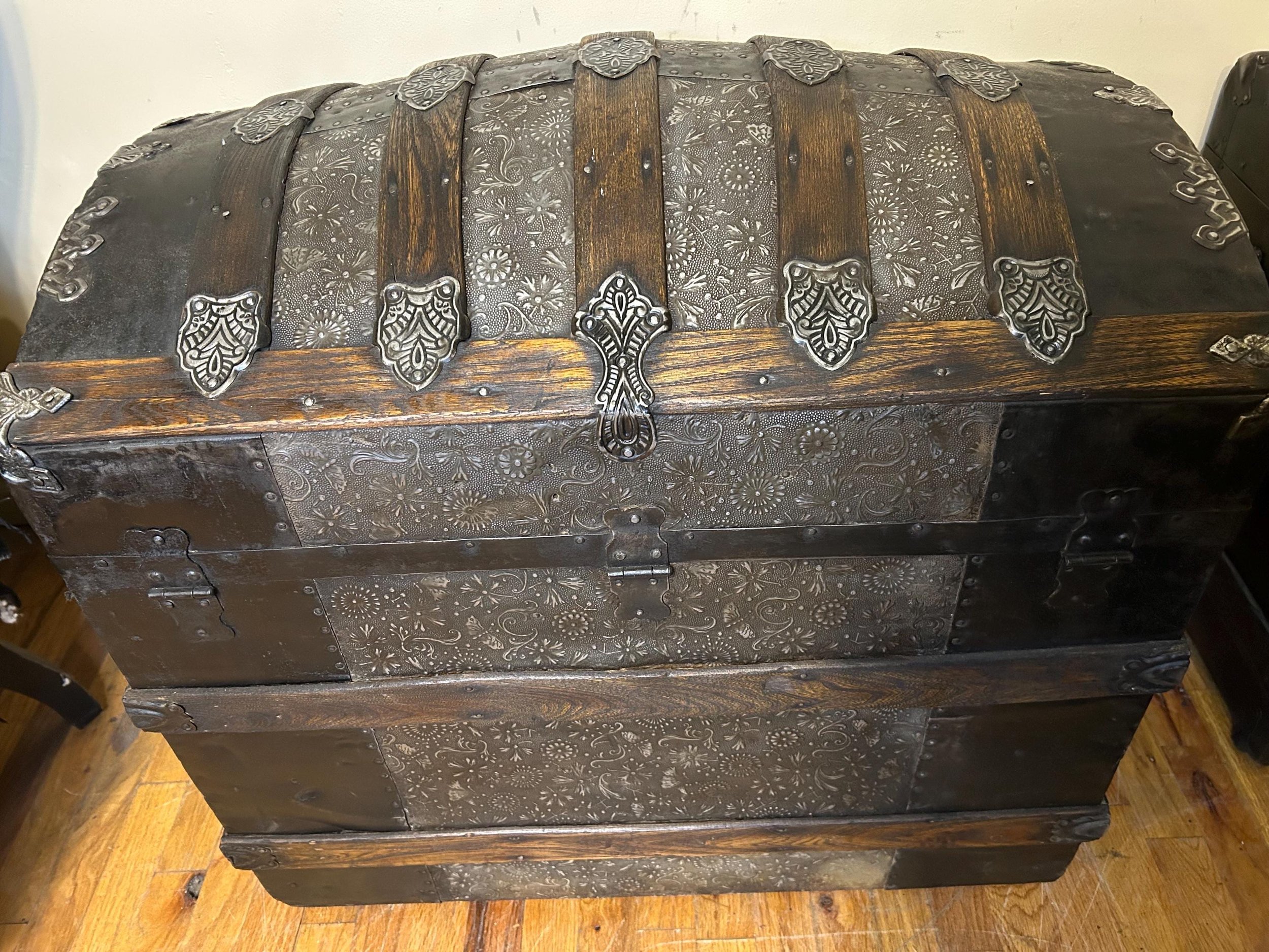 View of the original heavy-duty hinges and back construction of a restored floral trunk.