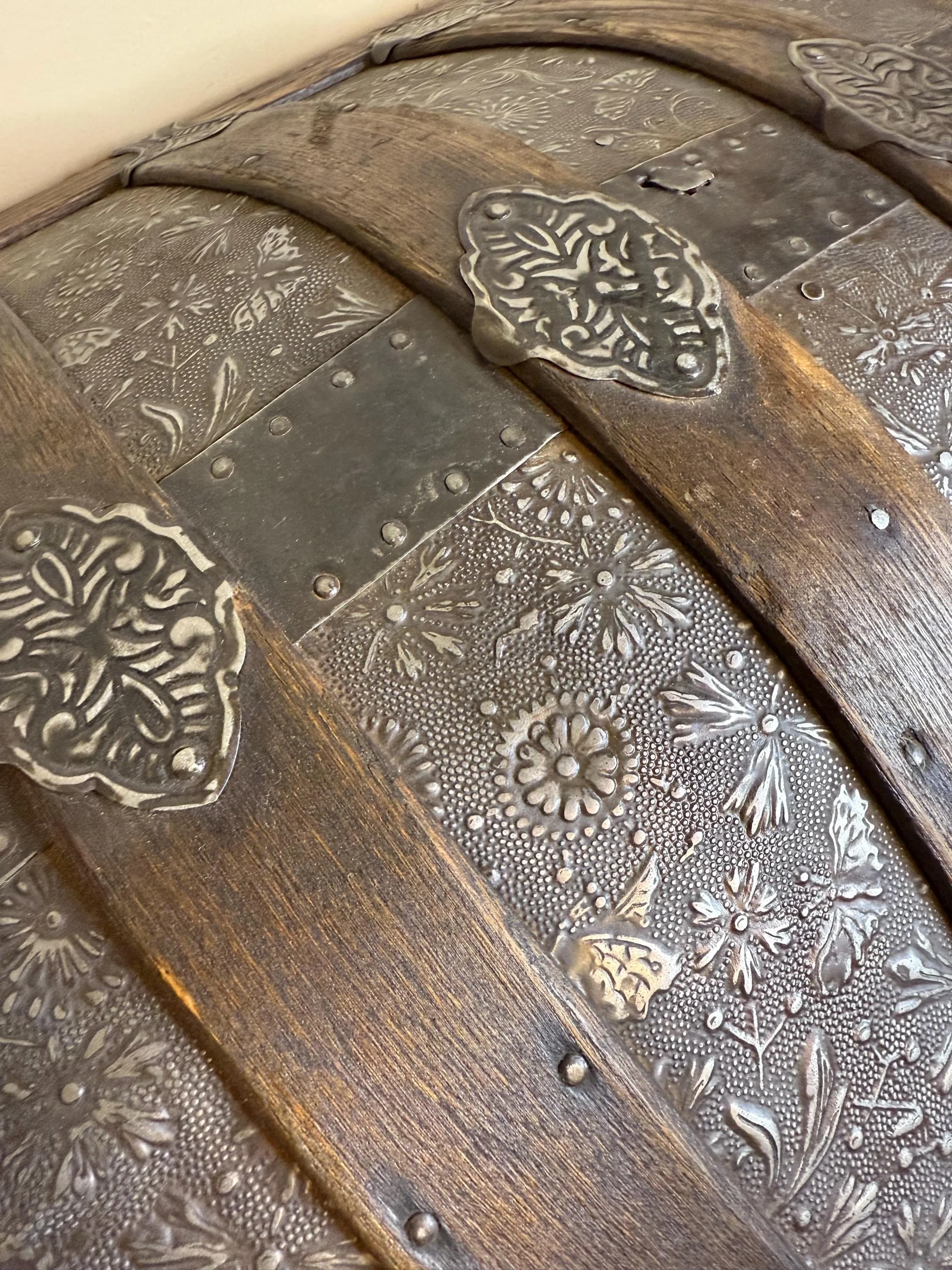 Intricate floral metalwork detail on a professionally restored antique chest.