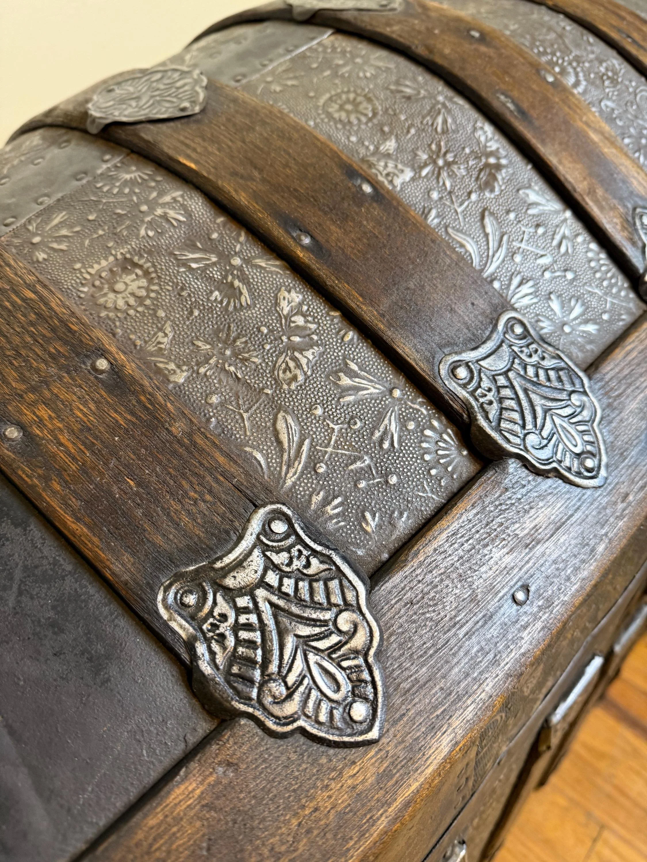 Original metal rivets and reinforced wood banding on a 19th-century floral chest.
