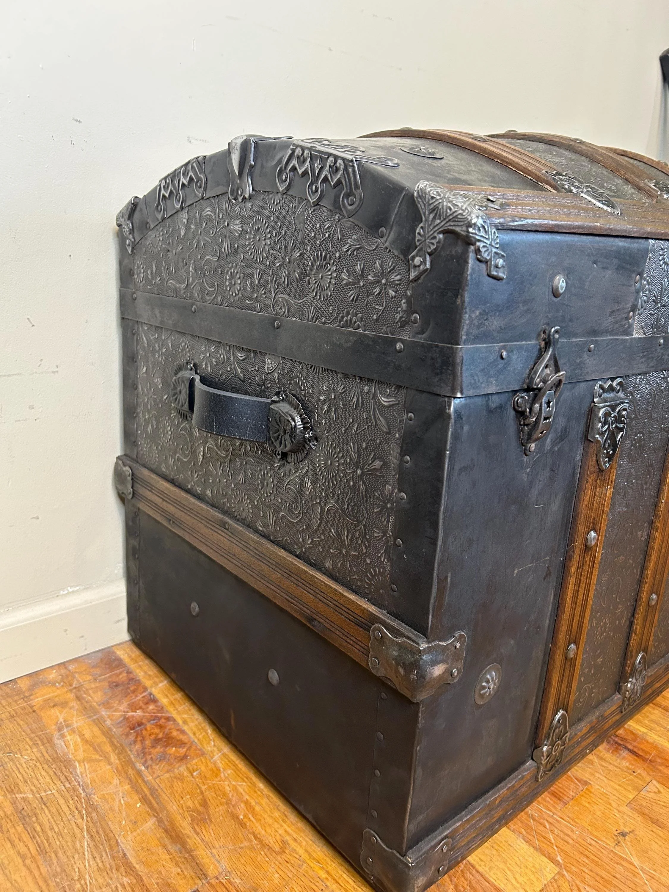 Side profile highlighting the high arched dome lid of a 19th-century travel trunk.