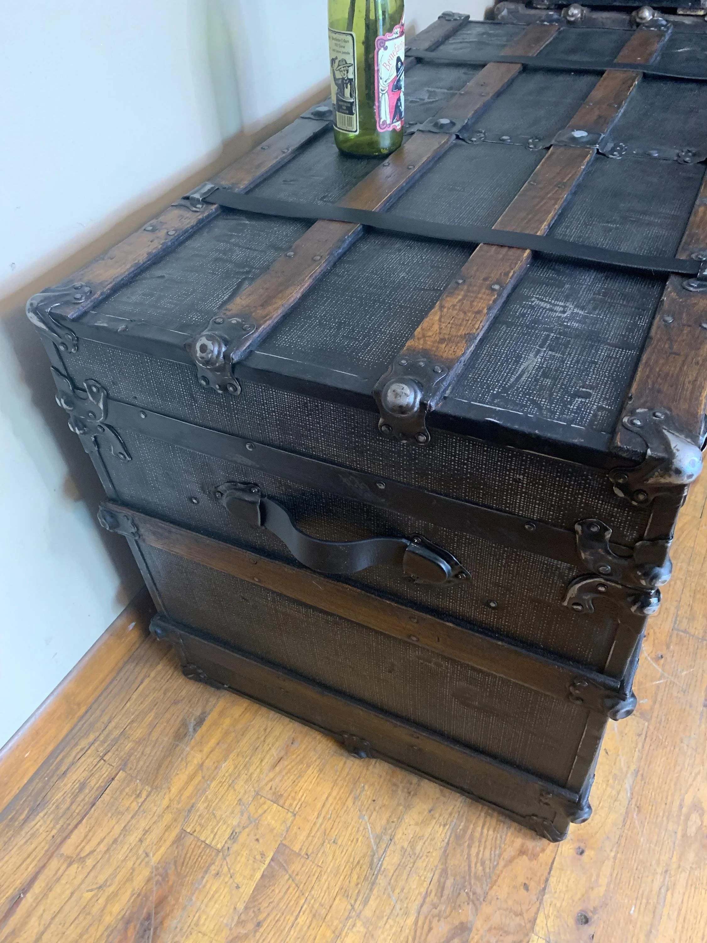 Side view highlighting the massive scale of this 19th-century travel chest