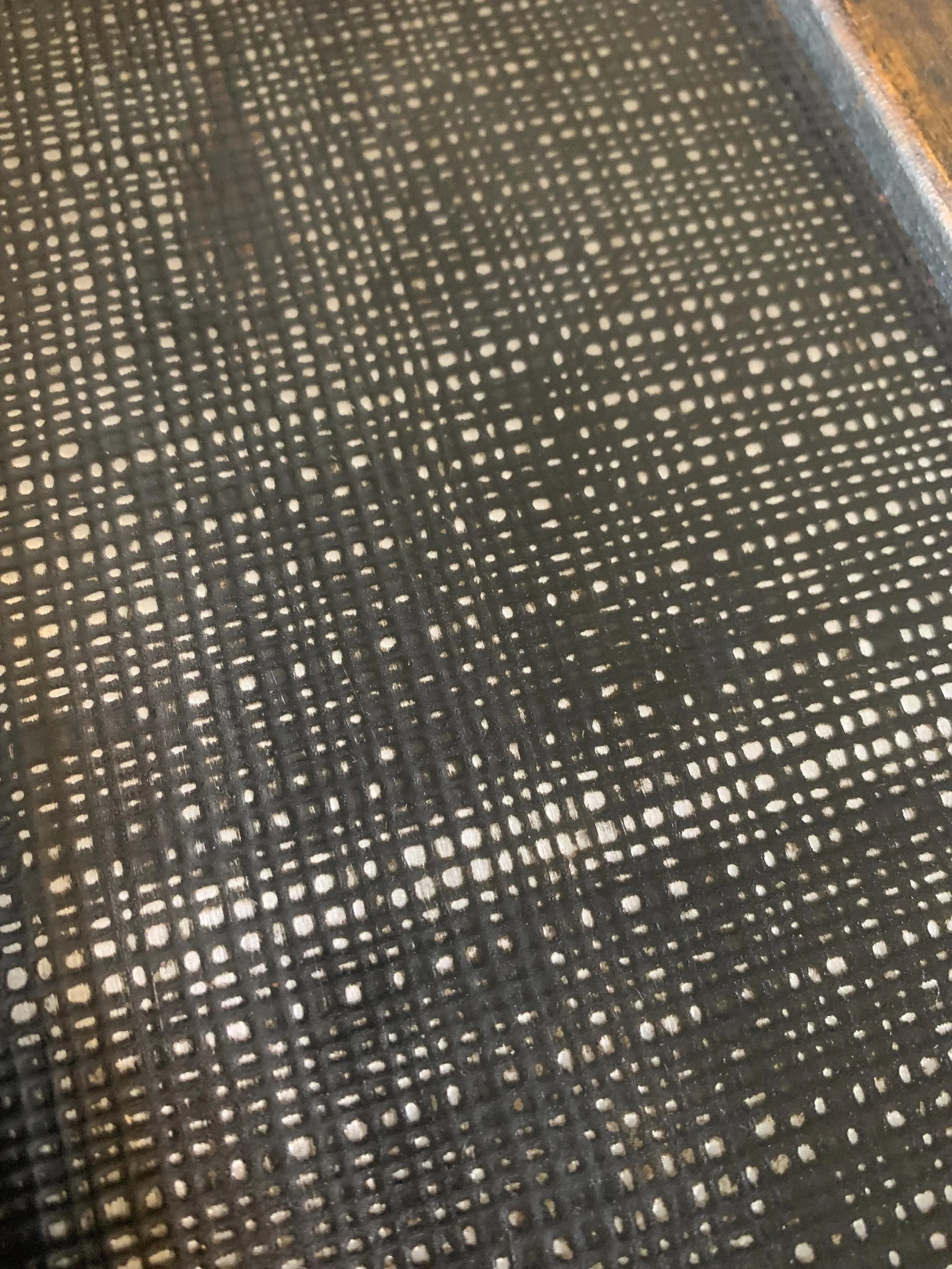 Detailed close-up of the rare relief pattern on an 1800s embossed tin trunk.