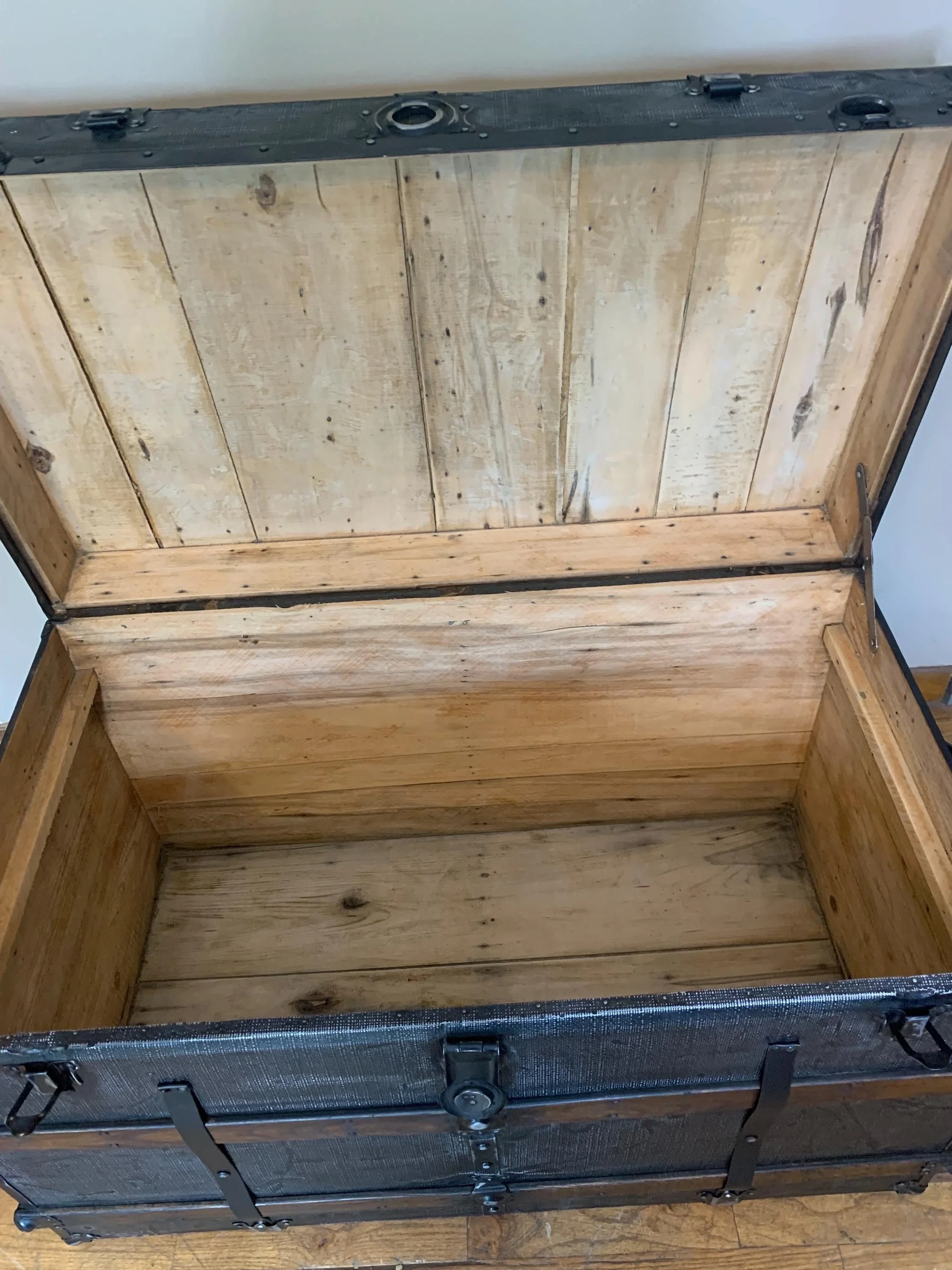Clean, stripped and sanded wood interior of an extra-large storage chest.