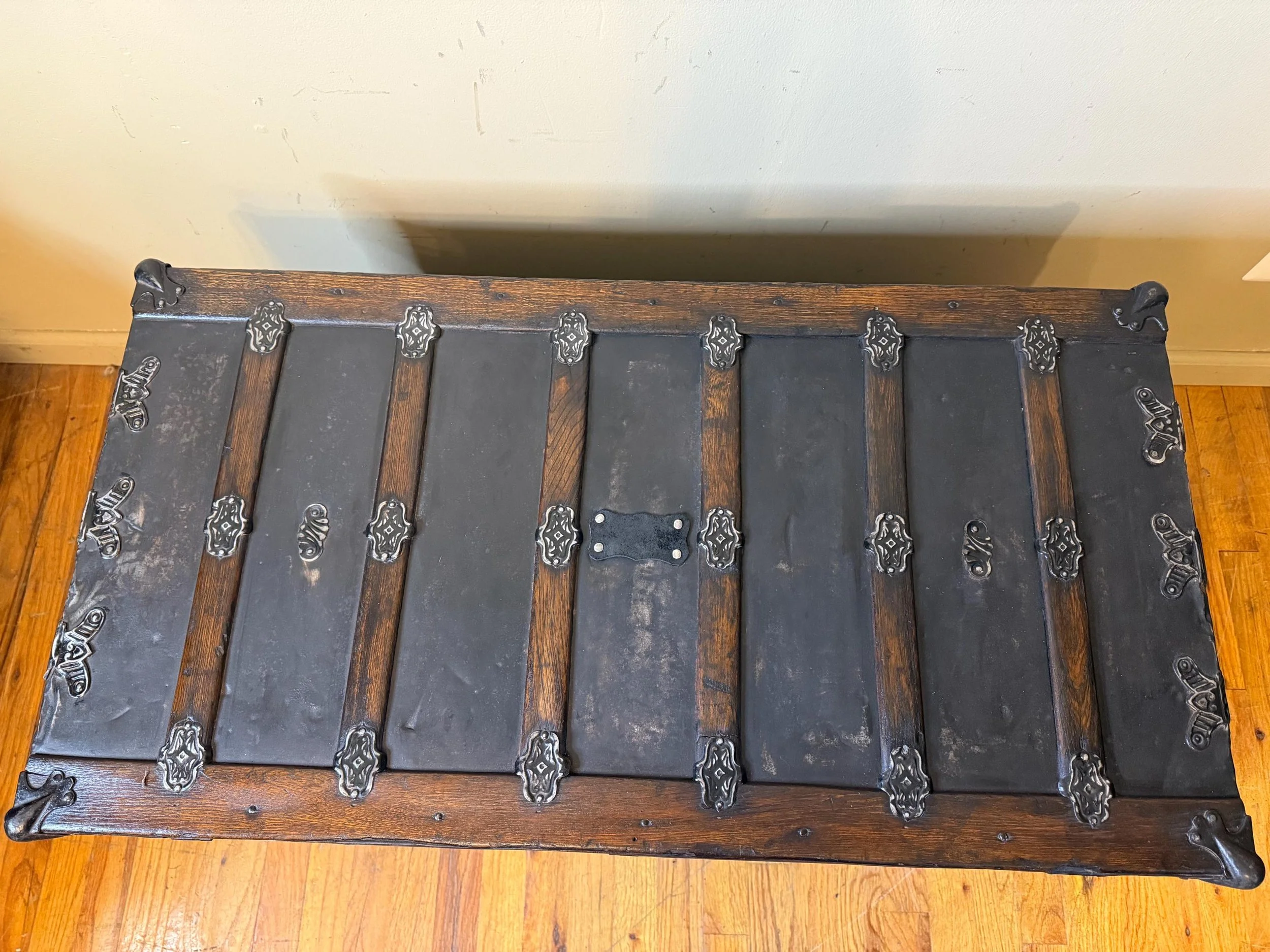 Solid oak wood slats restored in a rich walnut finish on a huge black chest.