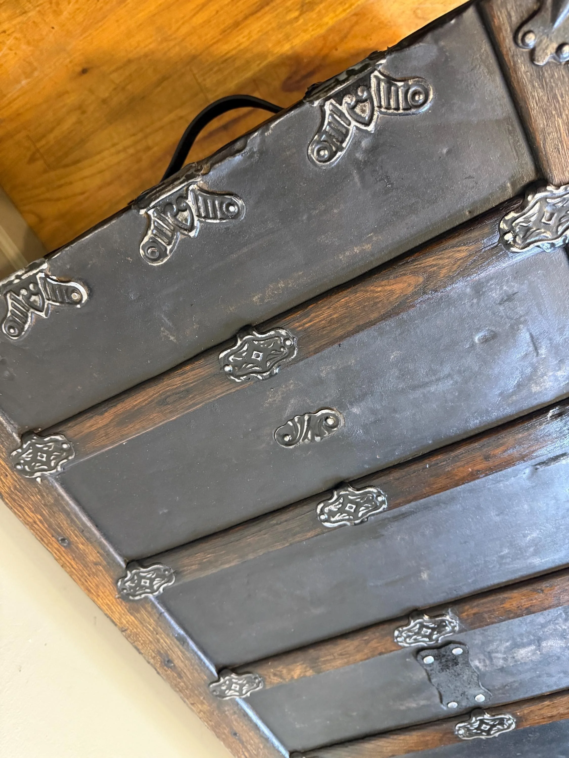 Detailed close-up of the rare relief pattern on an 1800s embossed tin trunk.