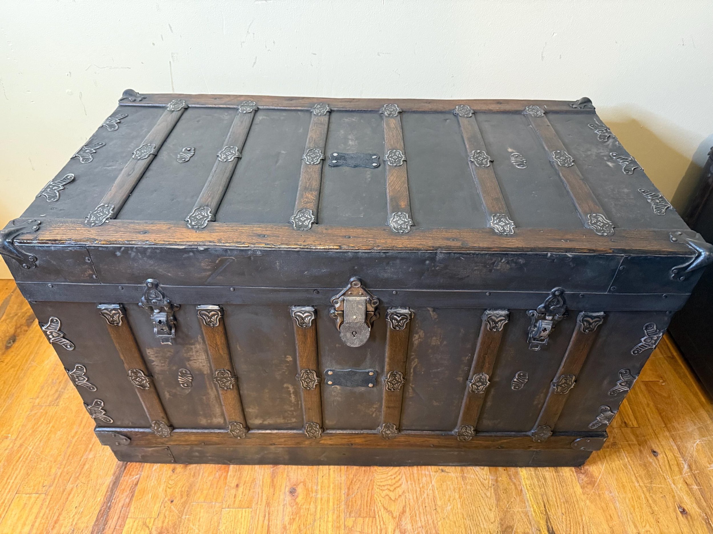 Large flat top antique trunk repurposed as an oversized industrial coffee table.