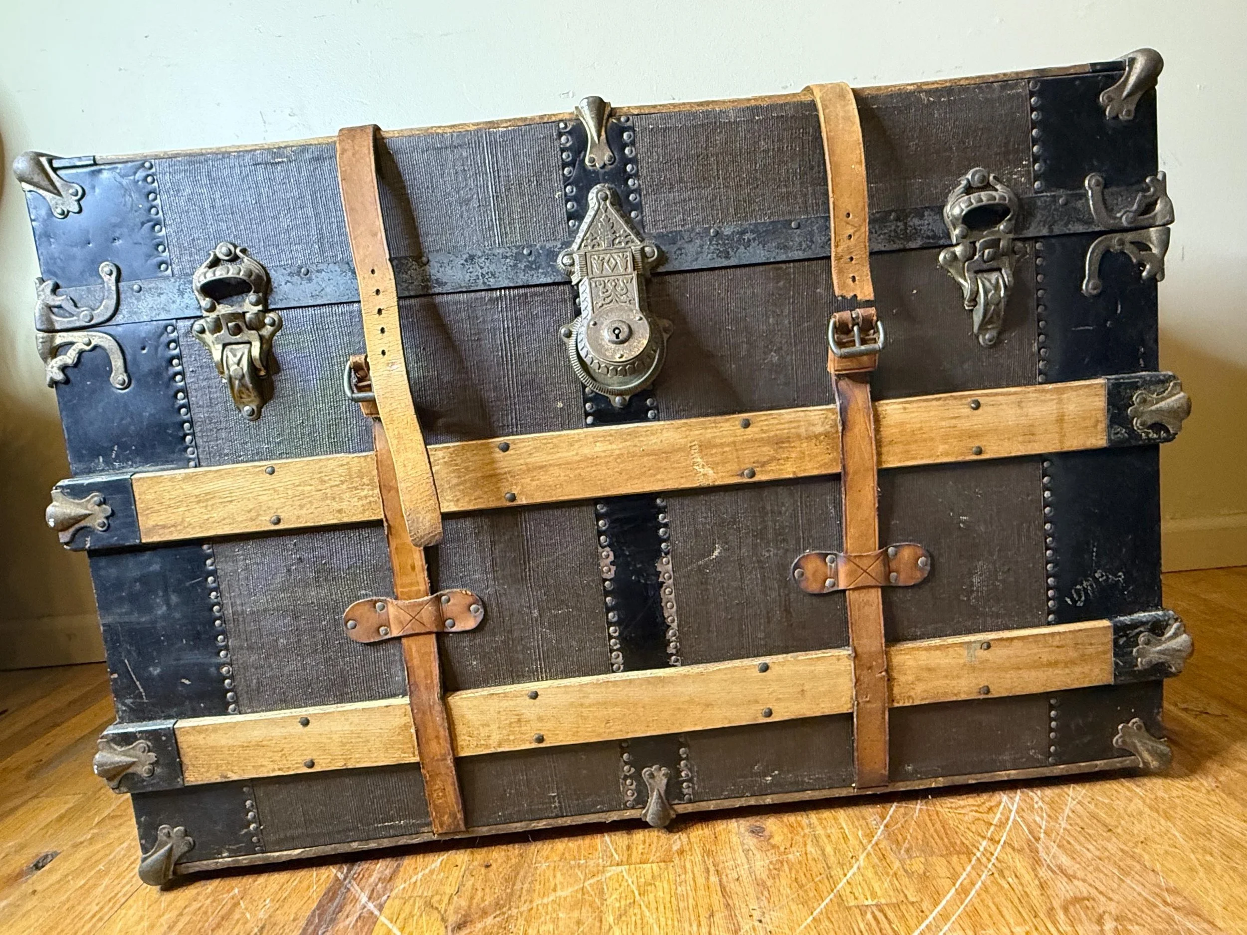 Large flat top antique steamer trunk used as a rustic industrial coffee table