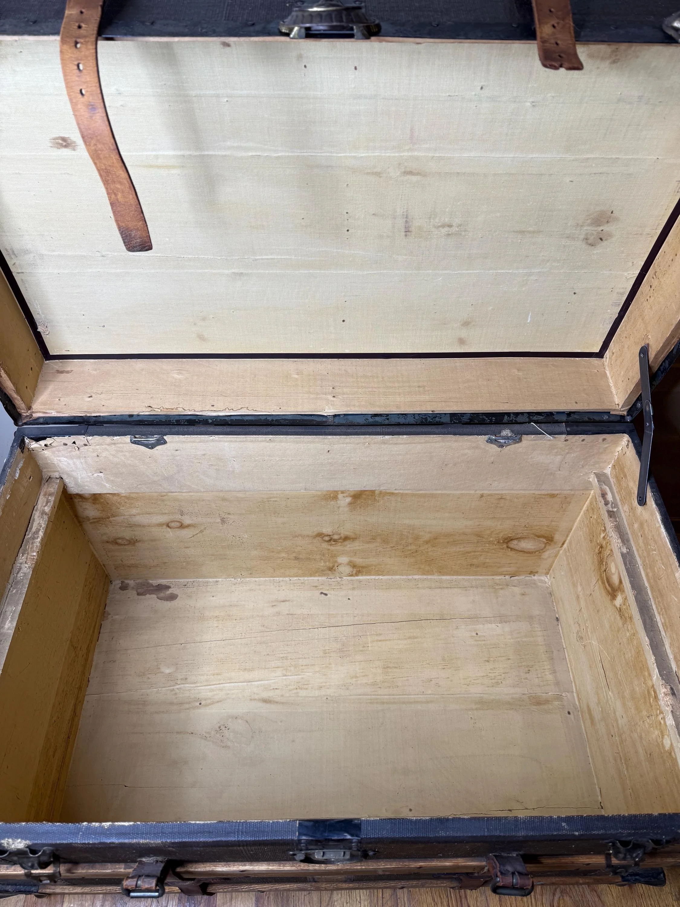 Industrial coffee table trunk with a black and brown weathered finish.