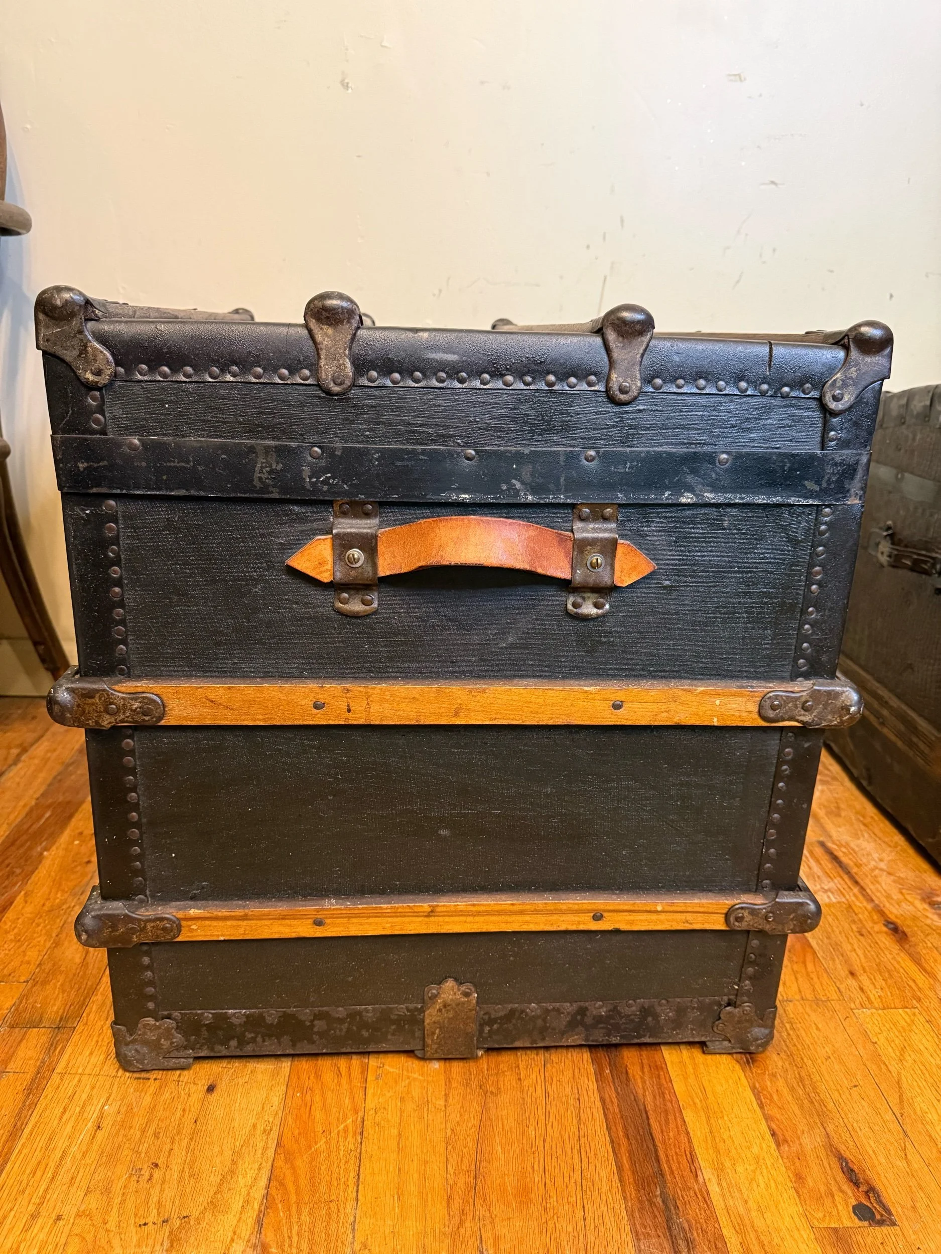 Vintage travel trunk featuring aged leather handles