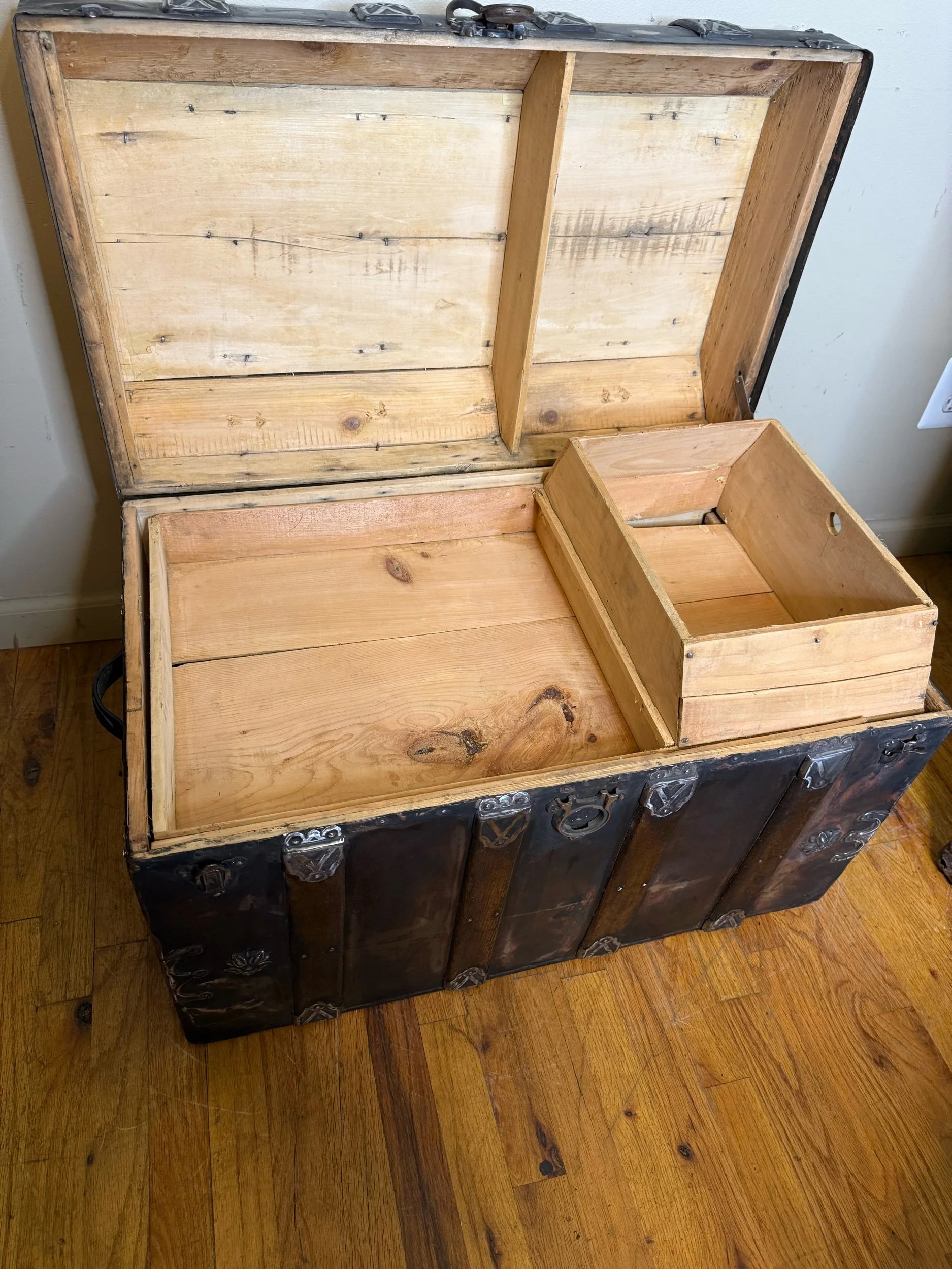 Interior of antique steamer trunk with sanded wood storage compartment