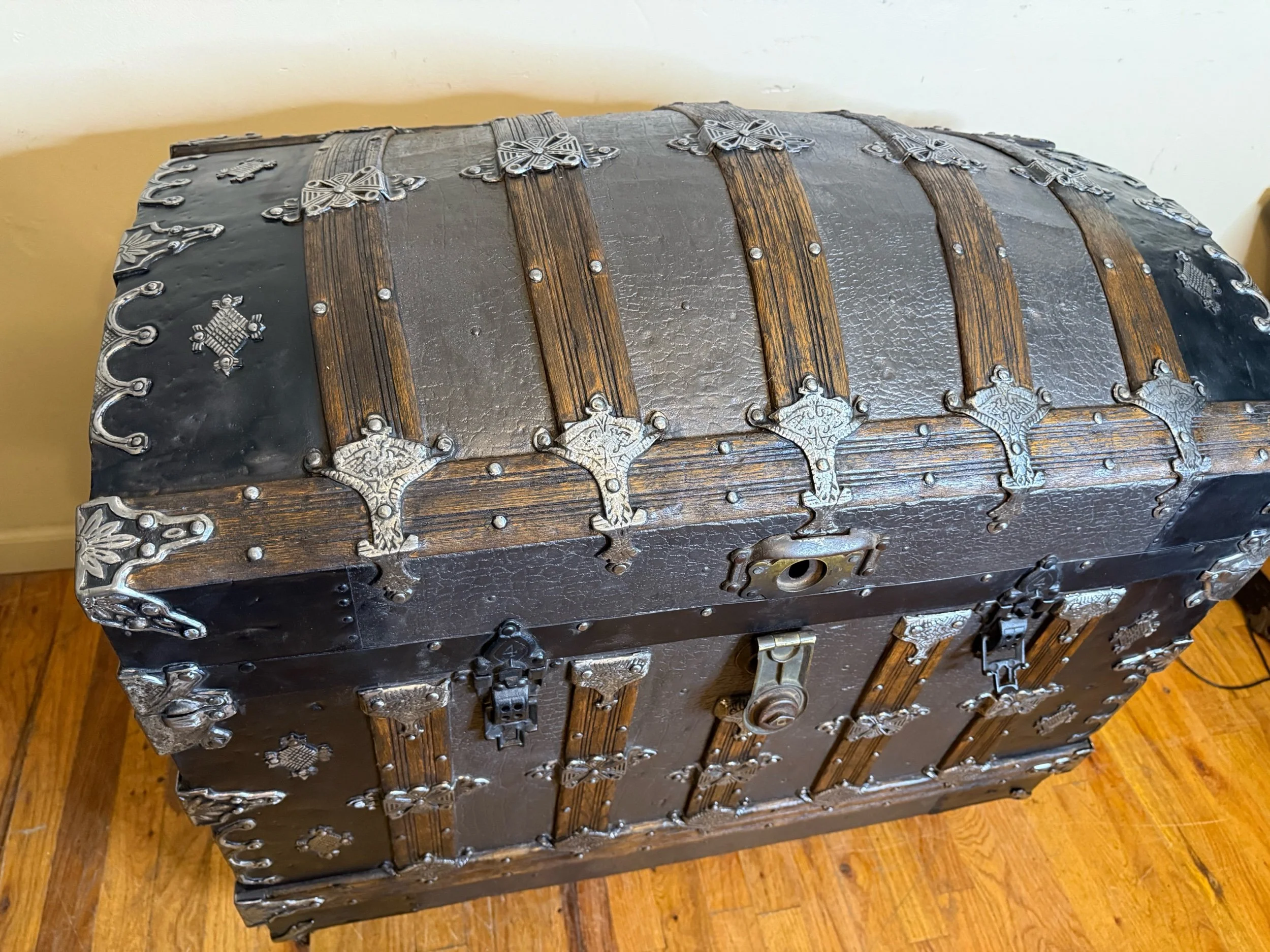 Antique dome top trunk with iridescent deep brown embossed tin