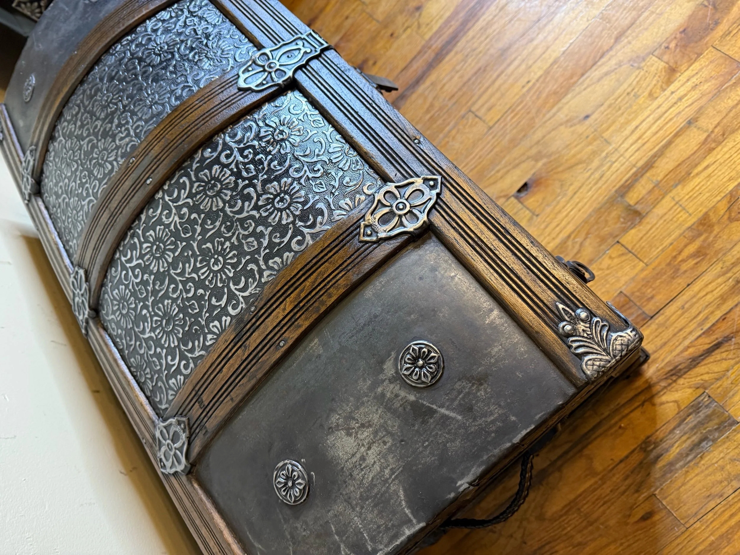 Buffed floral embossed tin against antiqued black finish