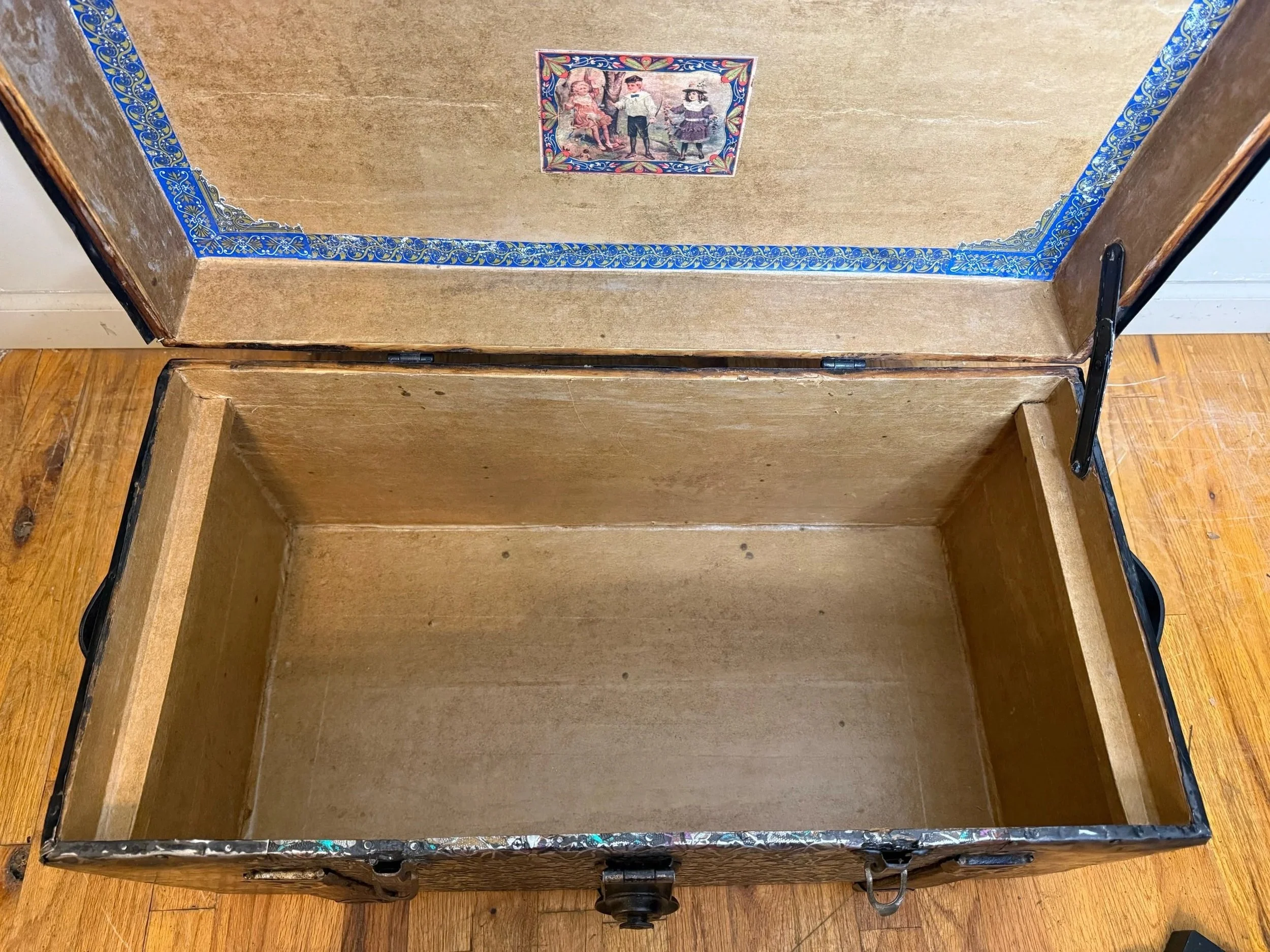 Original interior of antique steamer trunk with preserved paper lining