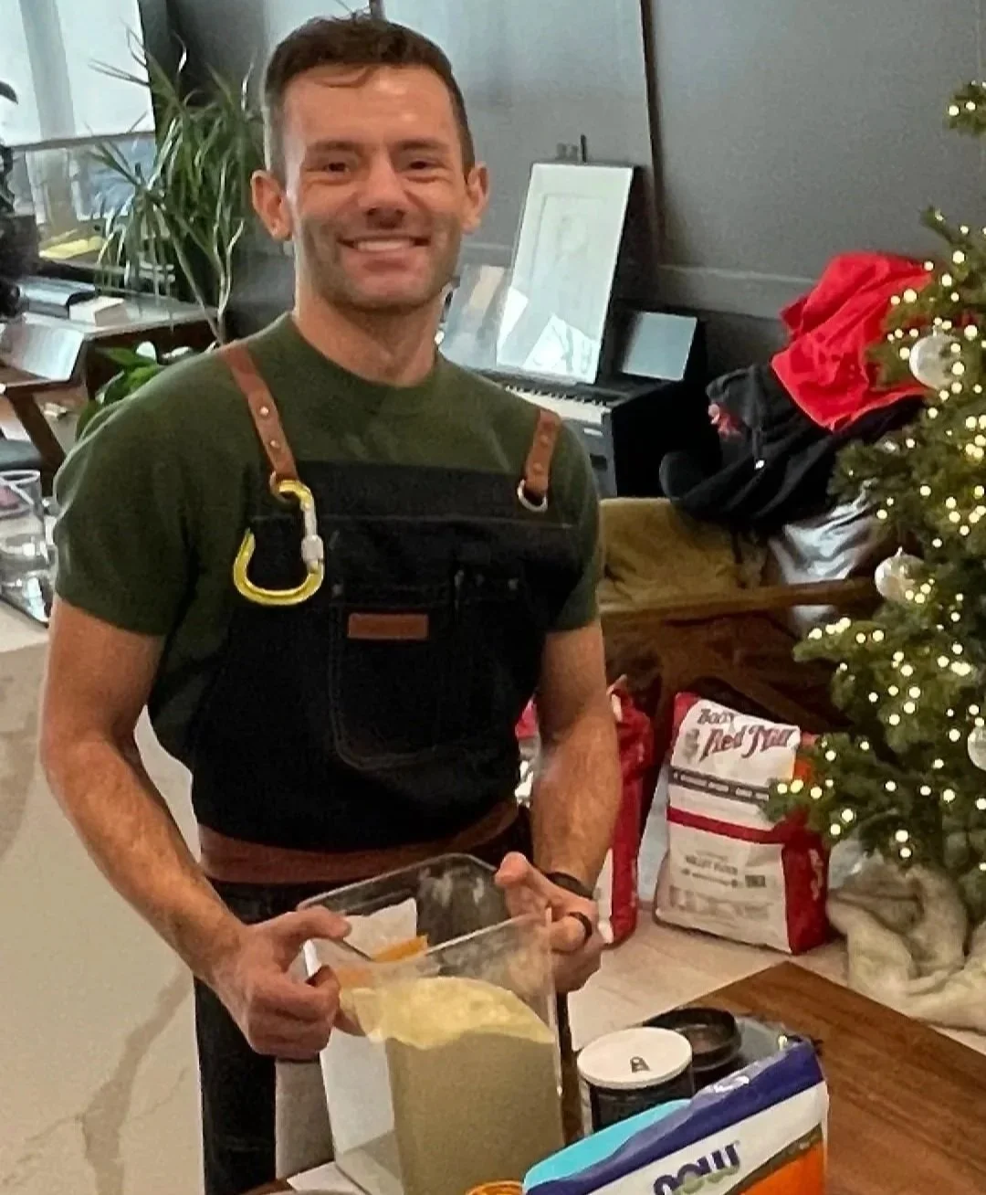 Ryan Michael Schmidt, Founder and Head Baker of The Common Crumb. Standing and smiling in kitchen.