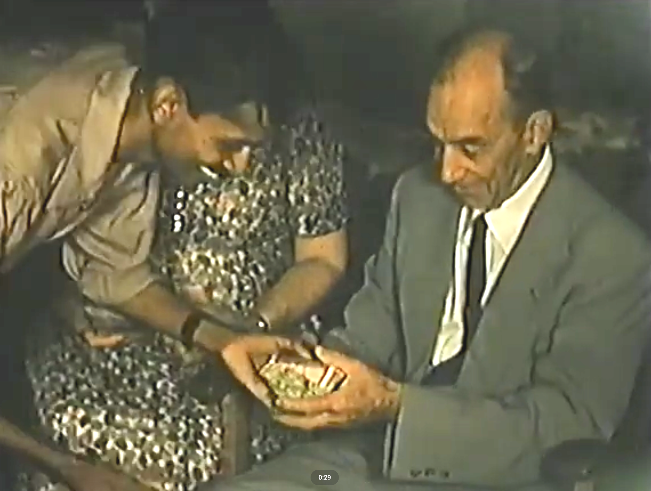 Jennie and Andrew Mitchell in Trinidad with church member giving his offering with a rock