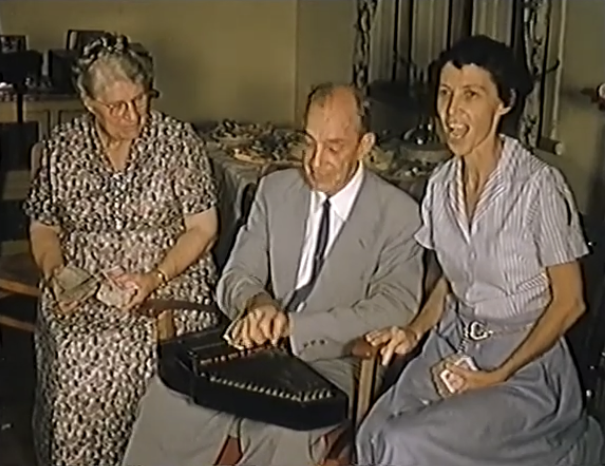 Jennie Mitchell and Jean Mitchell Wilhelmsen holding rocks with offering while Andrew plays the autoharp in Trinidad