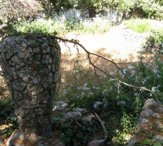 Photo from Aunt Eva's (A.E. Mitchell's sister) home sale listing showing the Victory Vase  under vines, 2017