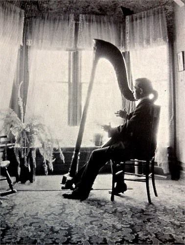 Andrew playing his harp in his Denver home