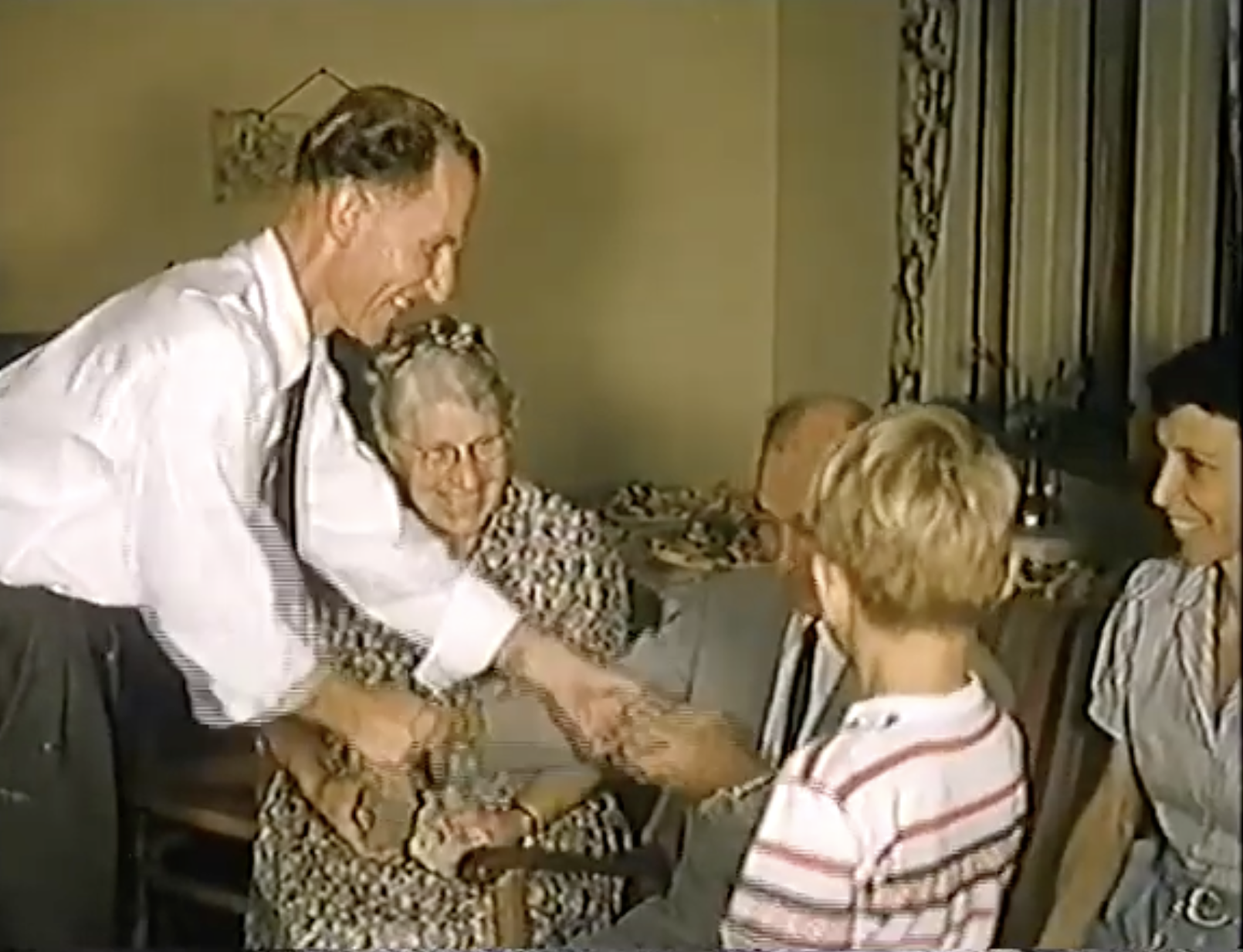 This still is from a video showing a man giving Andrew a rock with his offering in Trinidad with Jennie, daughter Jean, and grandson Bryant